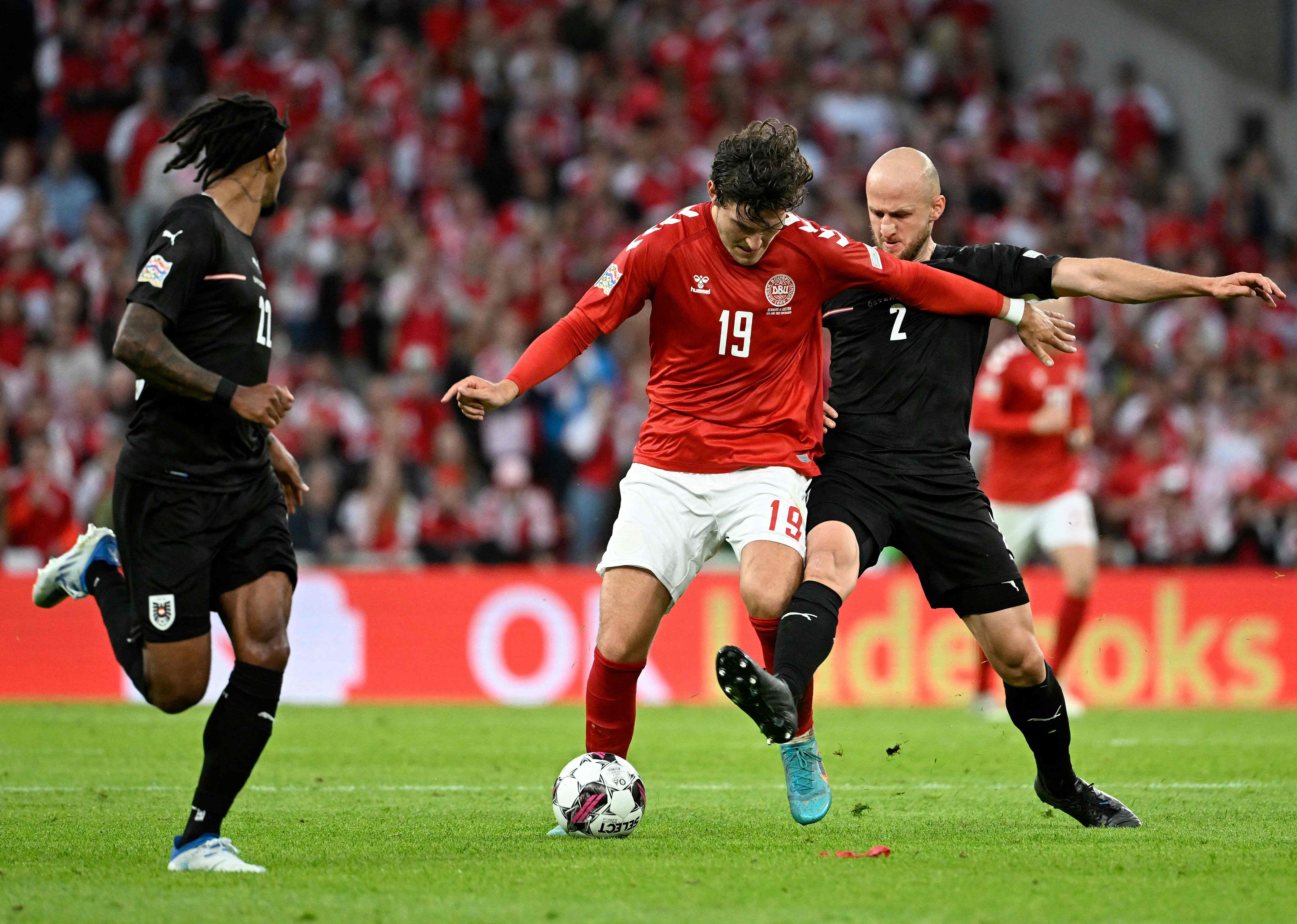 Penyerang Denmark Jonas Wind (tengah) berusaha melewati hadangan pemain Austria di laga Liga Negara UEFA.