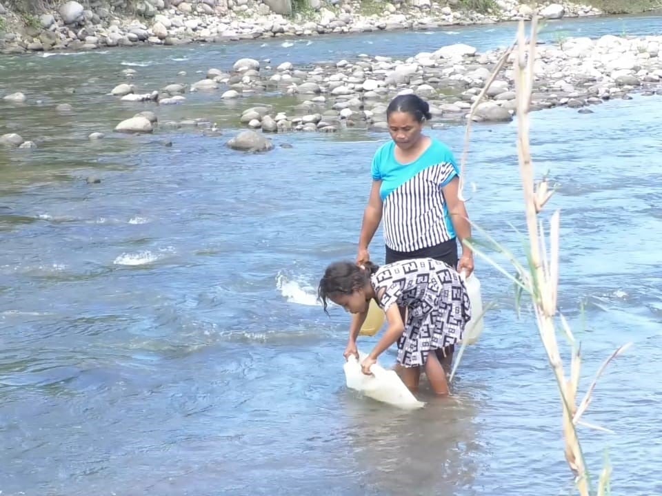 Imelda Ndeles dan anaknya, Oliv, sedang mengambil air sungai.