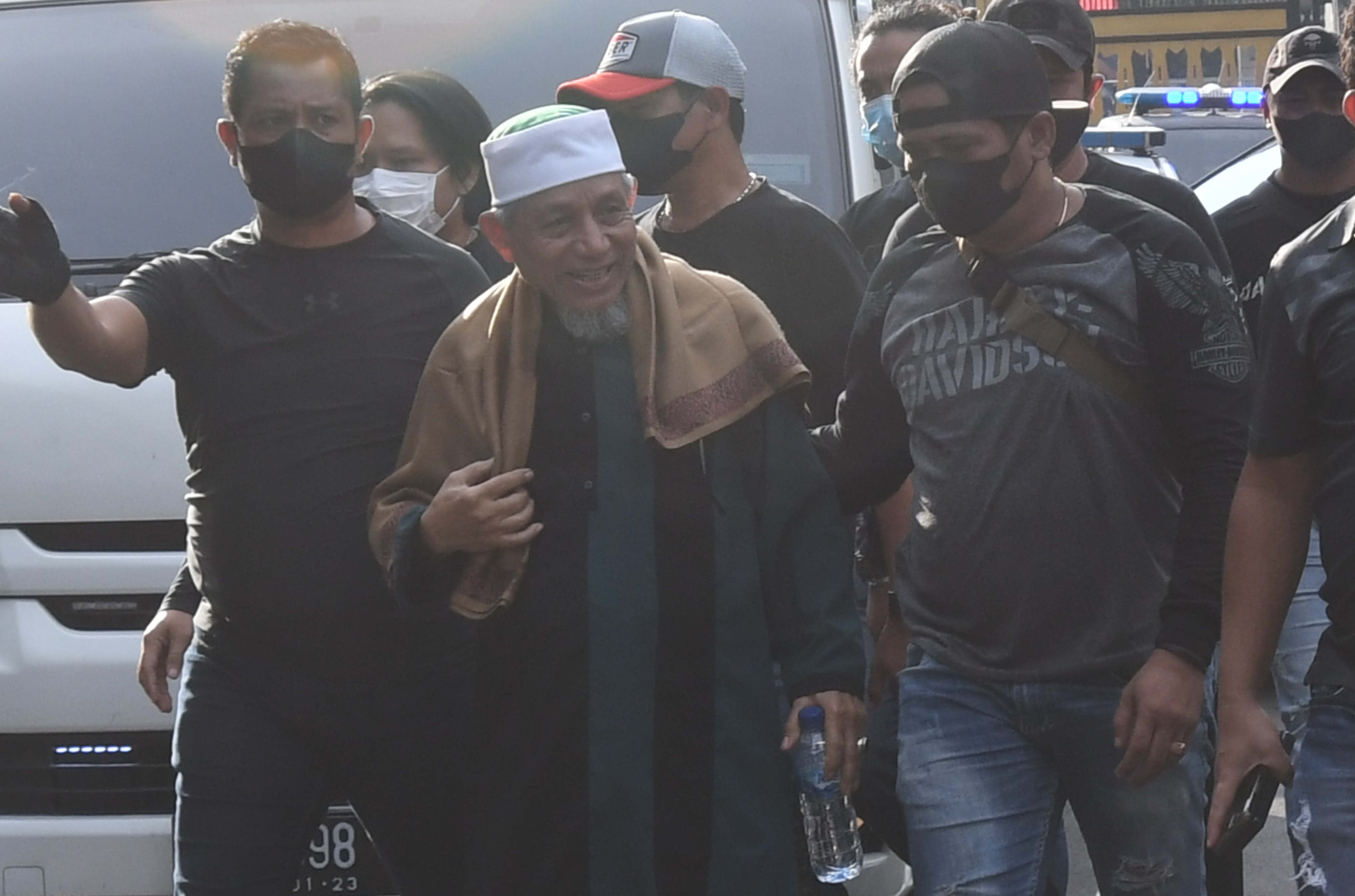 Polisi mengawal kedatangan petinggi organisasi Khilafatul Muslimin, Abdul Qadir Baraja (tengah), saat tiba di Polda Metro Jaya, Jakarta.