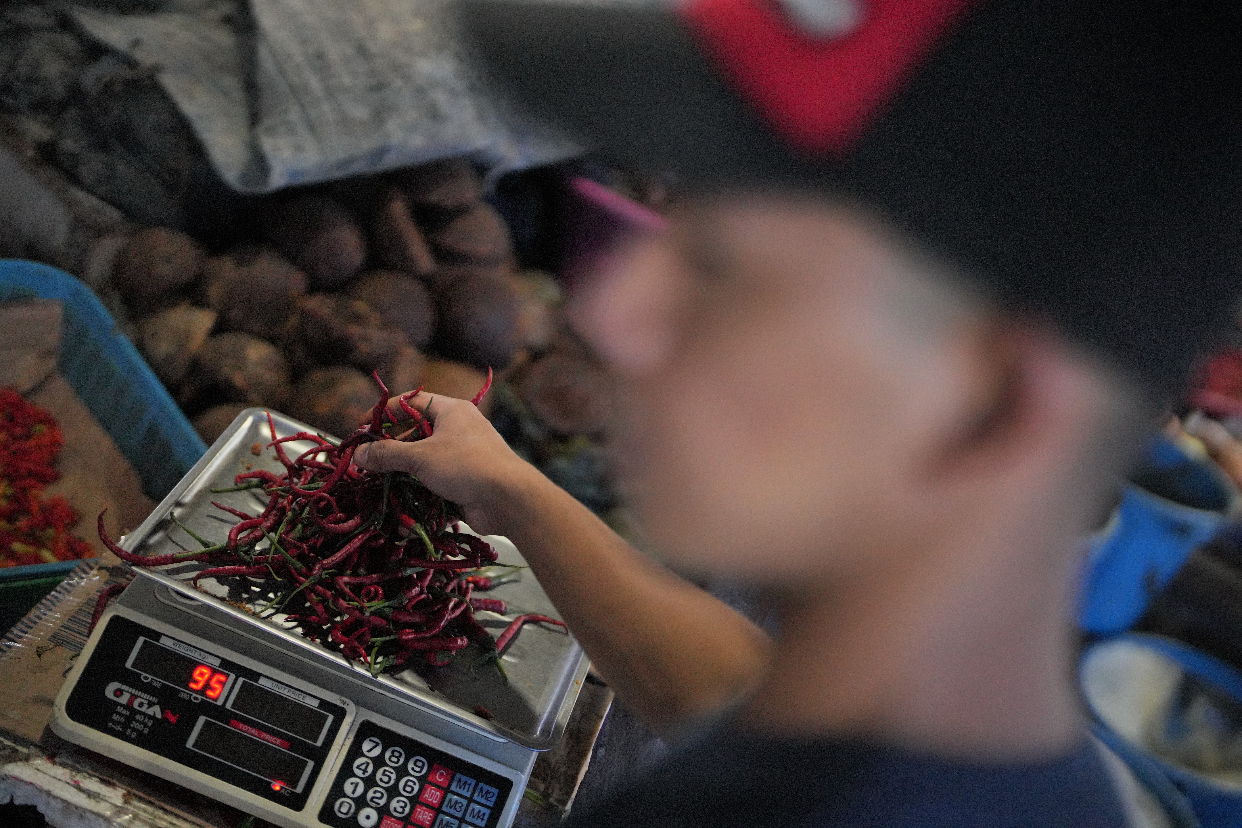 : Pedagang melayani pembeli cabai merah keriting di lapak jualannya di Pasar Basah Mandonga, Kendari, Sulawesi Tenggara, Jumat (24/6/2022)