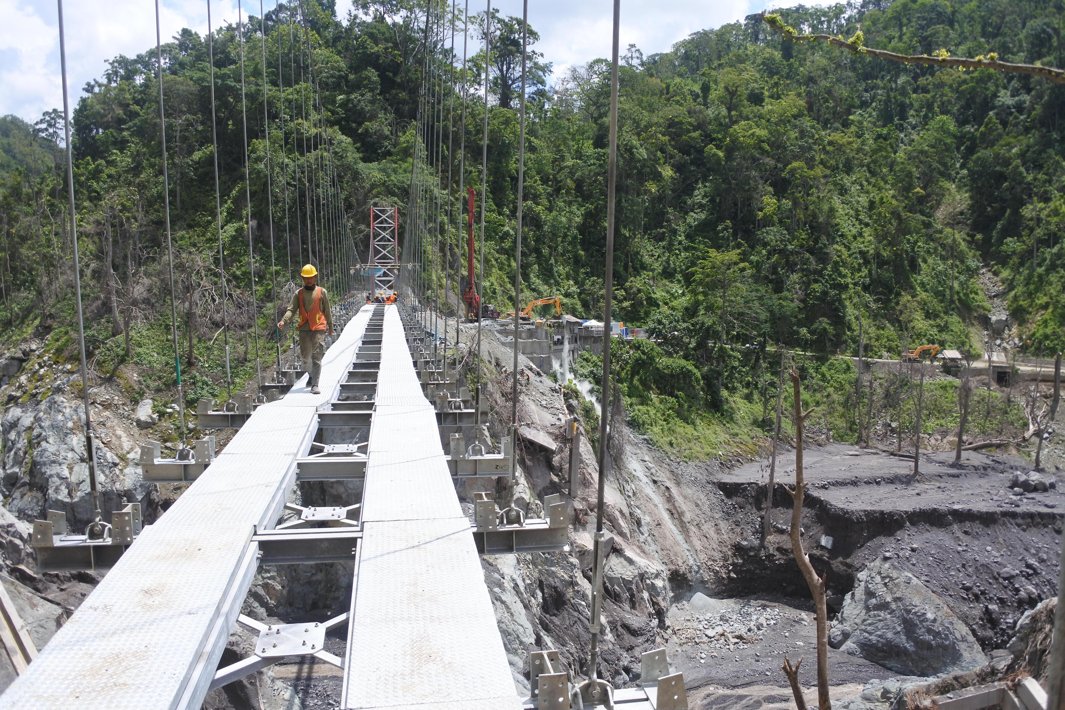 Sejumlah pekerja menyelesaikan pembangunan jembatan gantung di Lumajang, Jawa Timur.