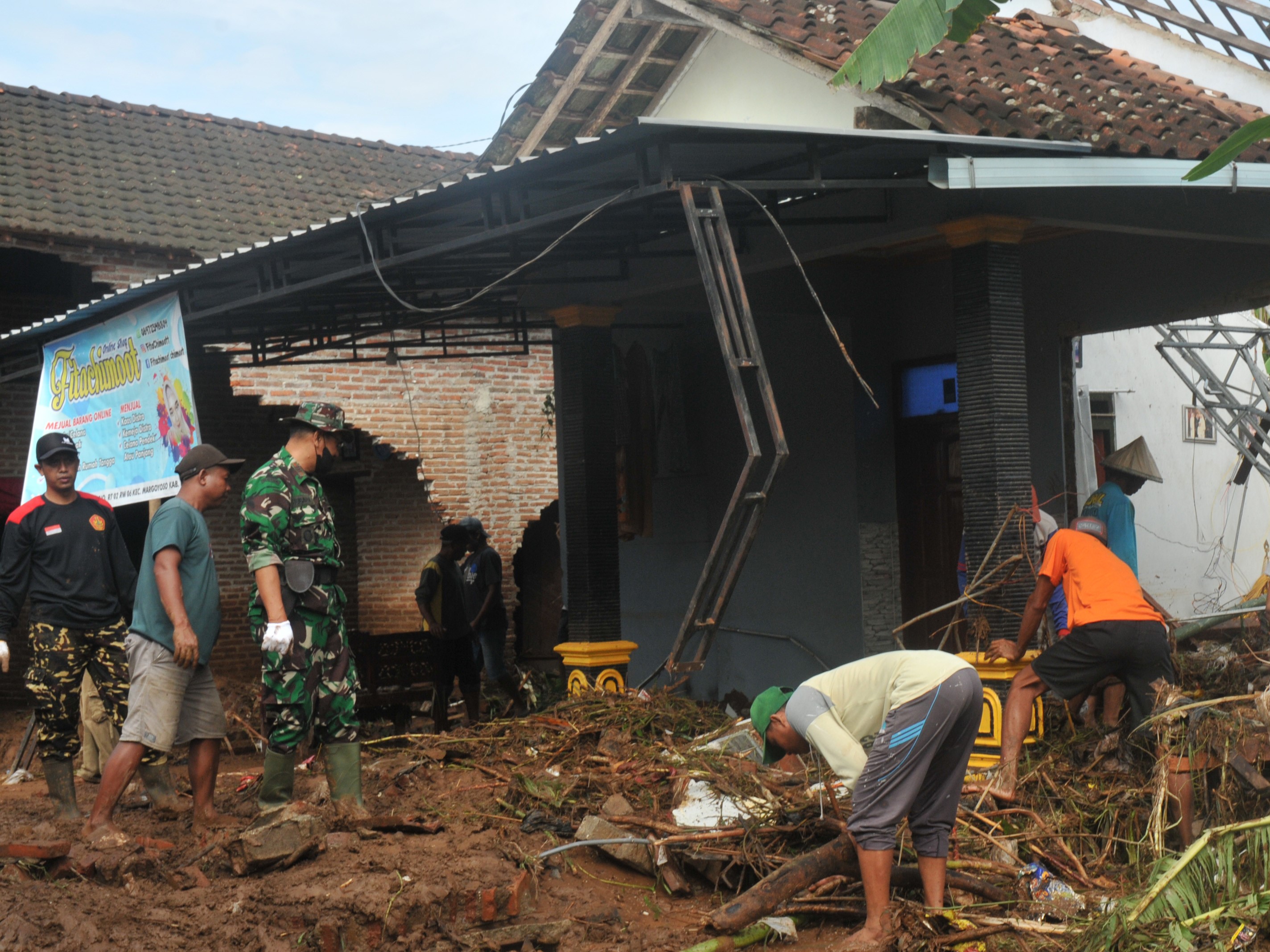 Warga bersama relawan dan TNI membersihkan material sisa banjir bandang di Desa Tunjungrejo, Margoyoso, Pati, Jateng, Selasa (28/6/2022).