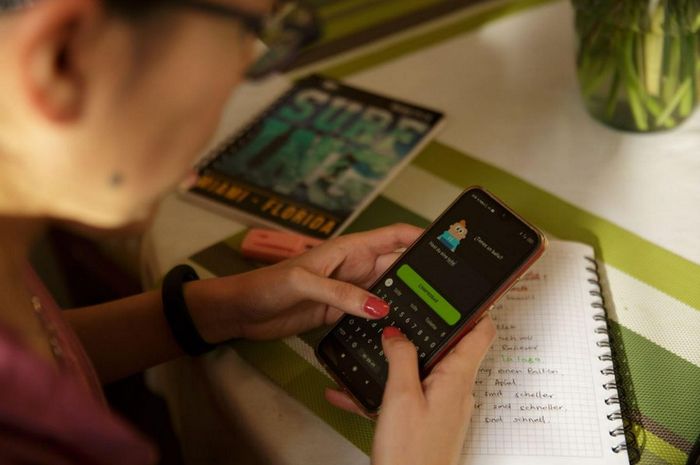 Pengguna menggunakan aplikasi Duolingo di ponsel.