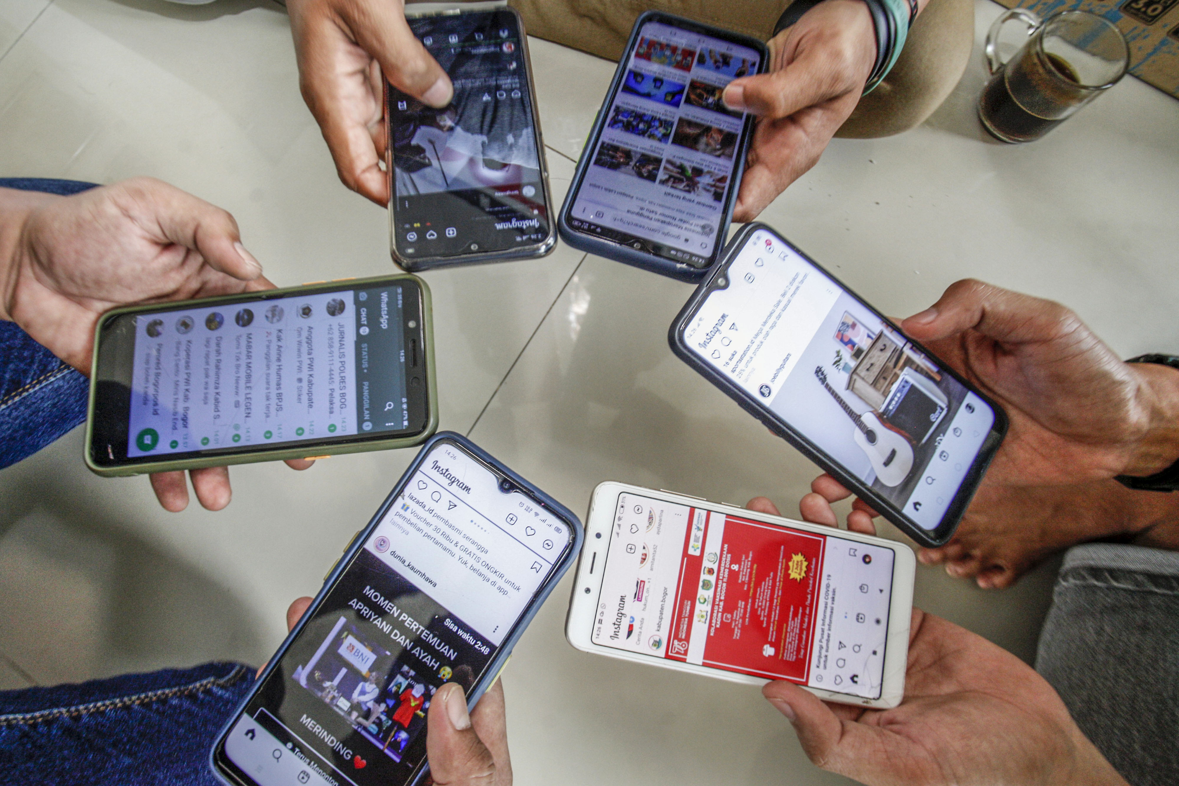 Warga mengakses internet dari perangkat ponsel mereka di Bogor, Jawa Barat.