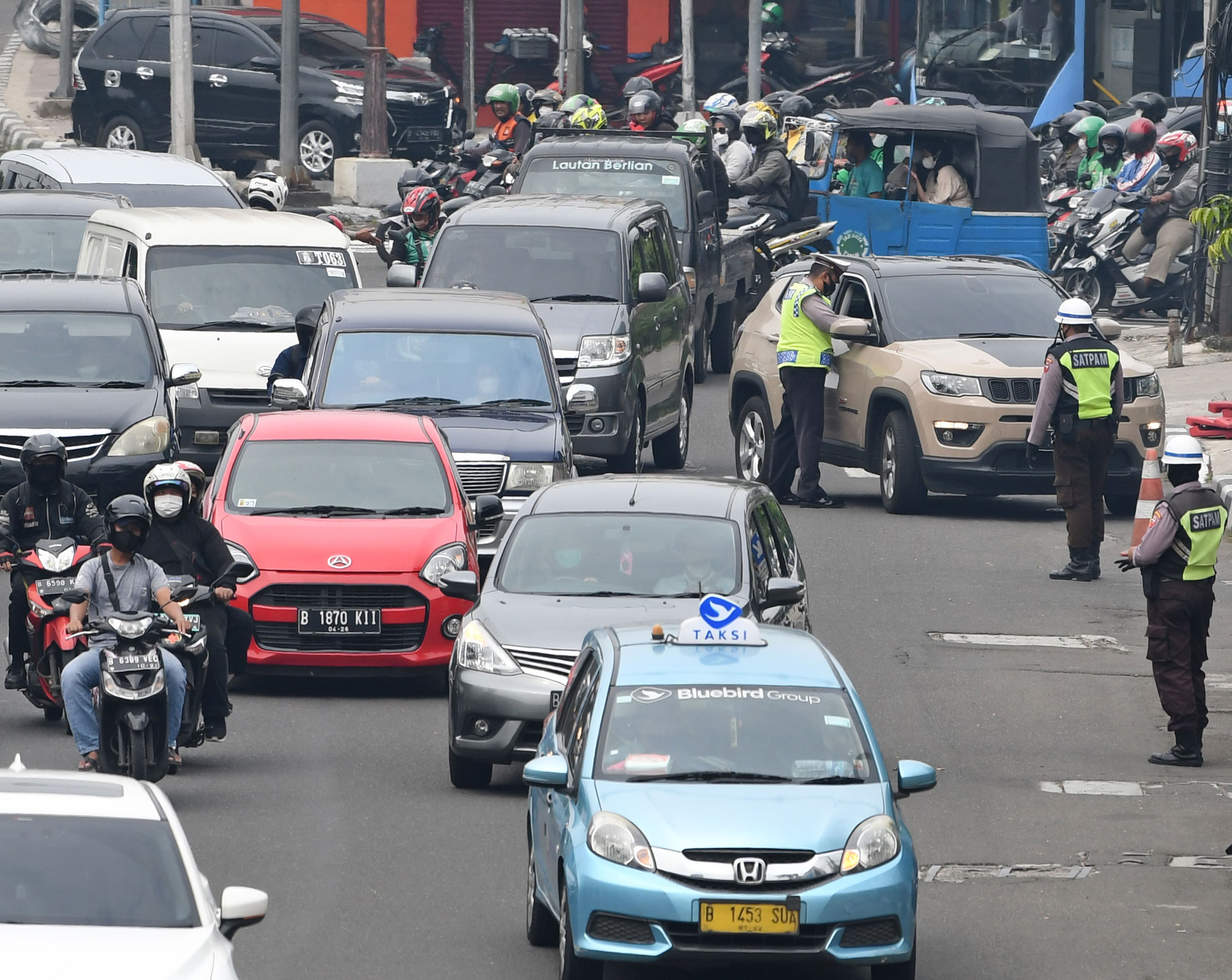  Sejumlah polisi lalulintas memberhentikan pengendara mobil yang melanggar peraturan saat pemberlakuan ganjil genap di Jakarta, Senin (6/6).