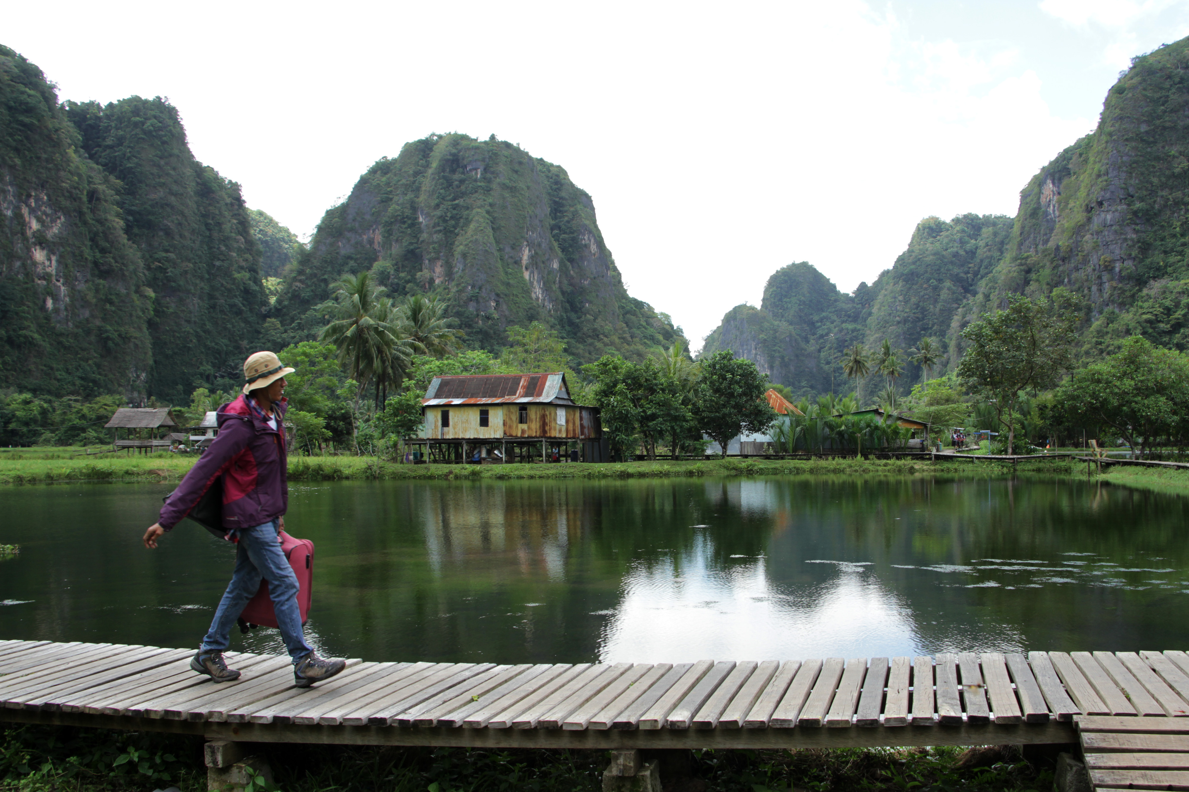Wisatawan melintas di area desa wisata Rammang-Rammang, Sulawesi Selatan.