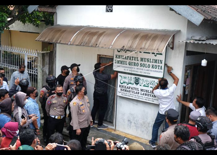 Polisi menurunkan papan bertulis Khilafatul Muslimin dari kantor cabang kelompok tersebut di Solo