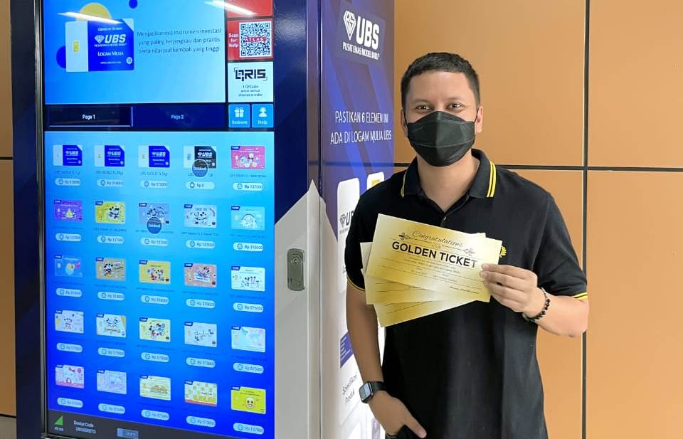 Youtuber dan Influencer Arief Muhammad berpose di samping Vending Machine Logam Mulia 24K UBS Gold.
