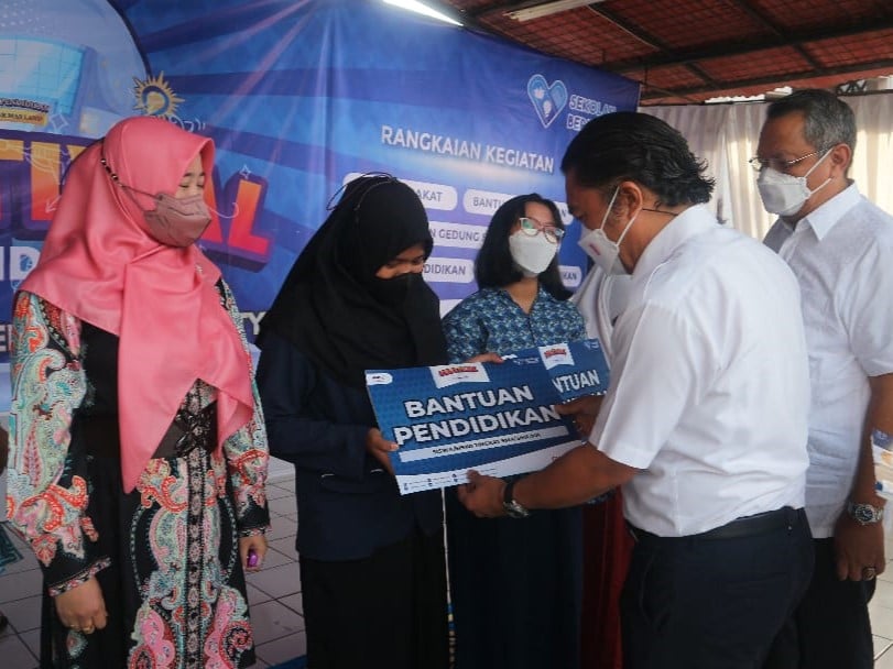 Al Muktabar didampingi Benyamin Davnie secara simbolis memberikan bantuan pendidikan kepada perwakilan tenaga pengajar.