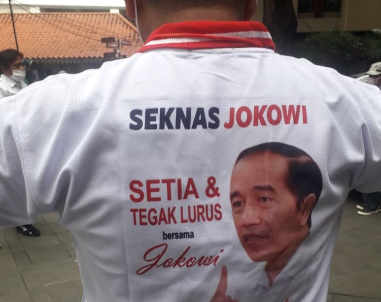 Seorang relawan Jokowi mengenakan kaos bertuliskan 'Seknas Jokowi', 'Setai & Tegak Lurus'.