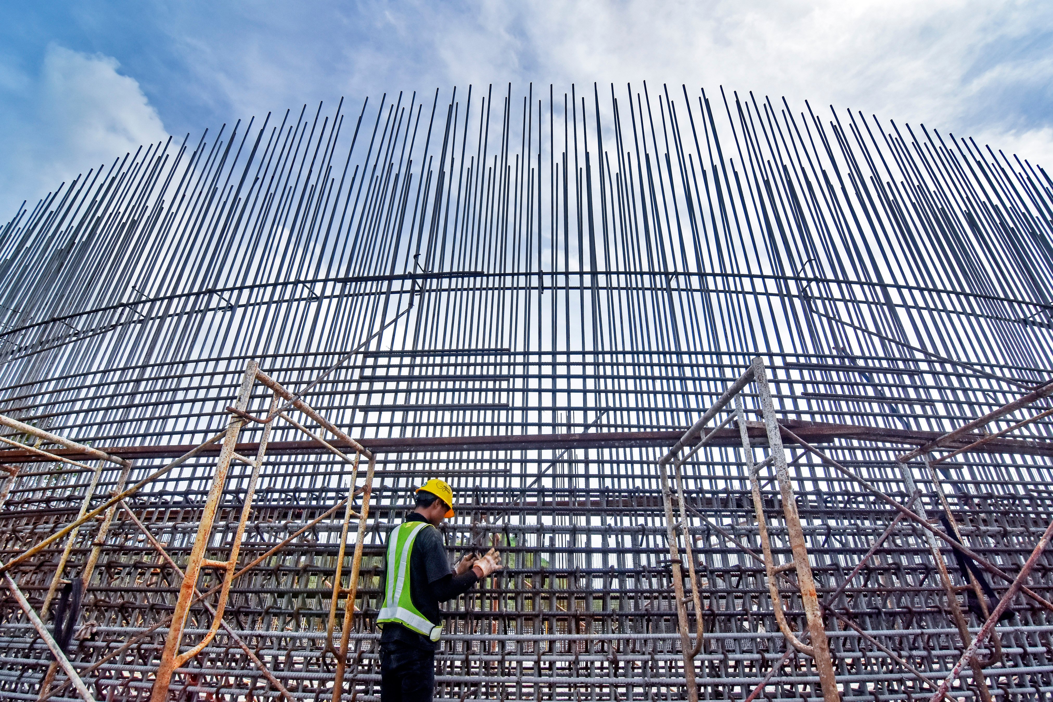  Pekerja mengikat konstruksi besi baja proyek pembangunan tangki air atau 