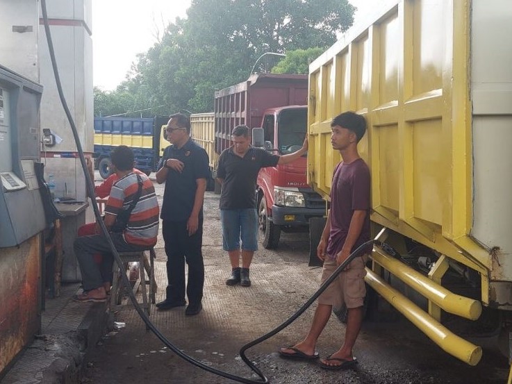 Christian Tory (berdiri berkacamata) menangkap basah sejumlah truk pengangkut batu bara mengisi BBM di SPBU, Kota Jambi.