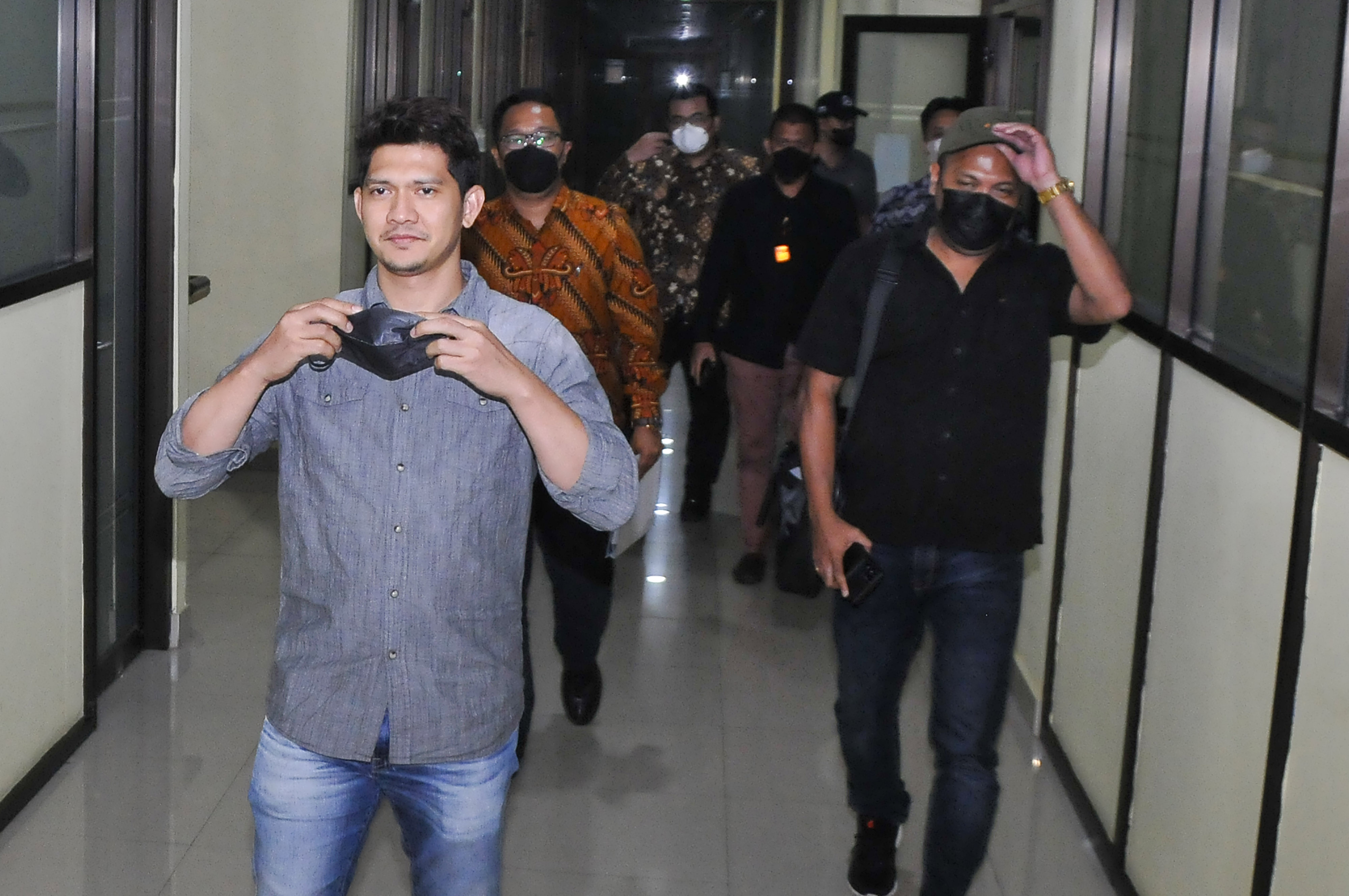 Aktor Iko Uwais (kiri) berjalan menuju kendaraan usai menjalani pemeriksaan di Polres Metro Bekasi Kota, Jawa Barat