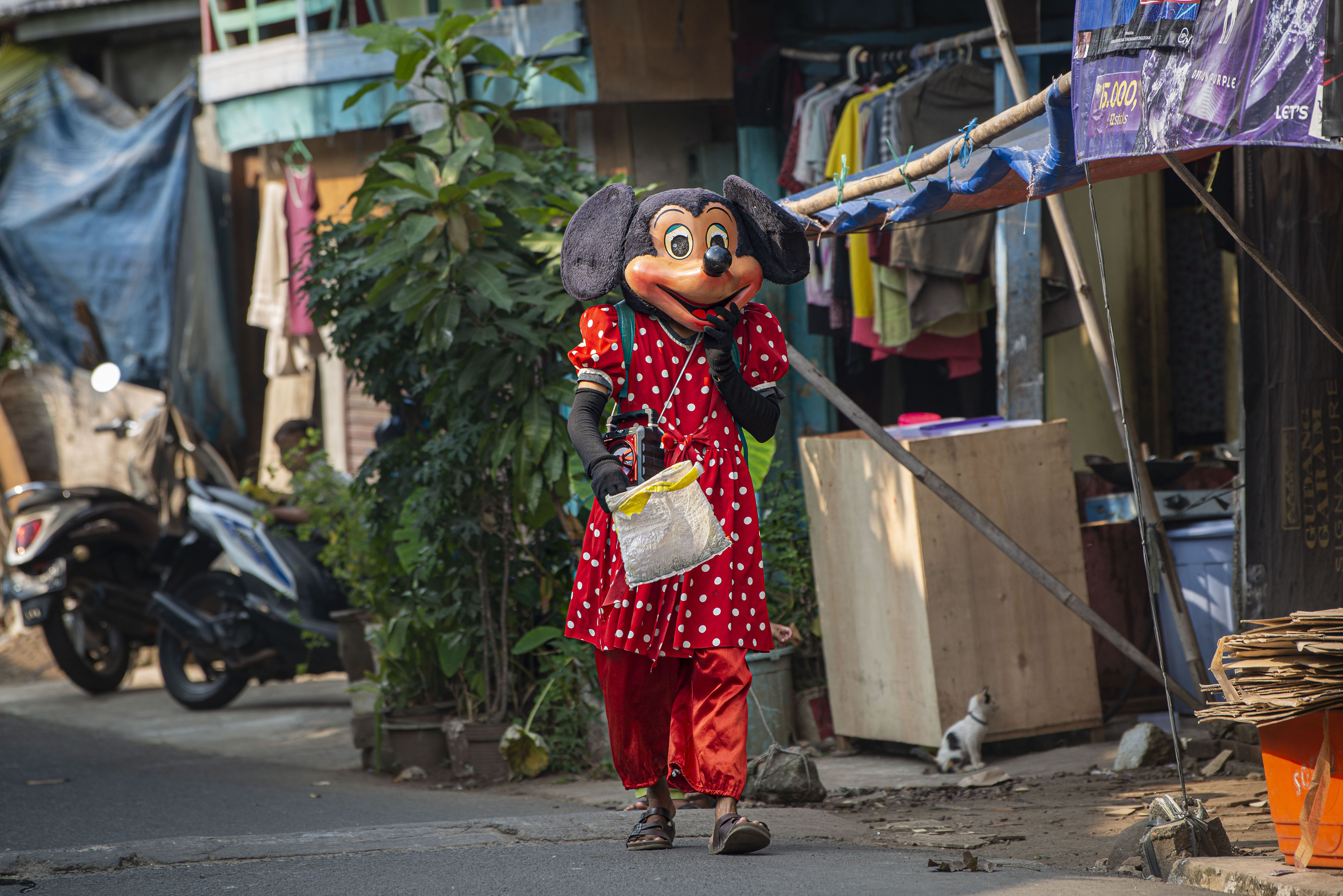 Pengamen dengan topeng tokoh kartun berkeliling di lingkungan padat penduduk di Manggarai, Jakarta Selatan