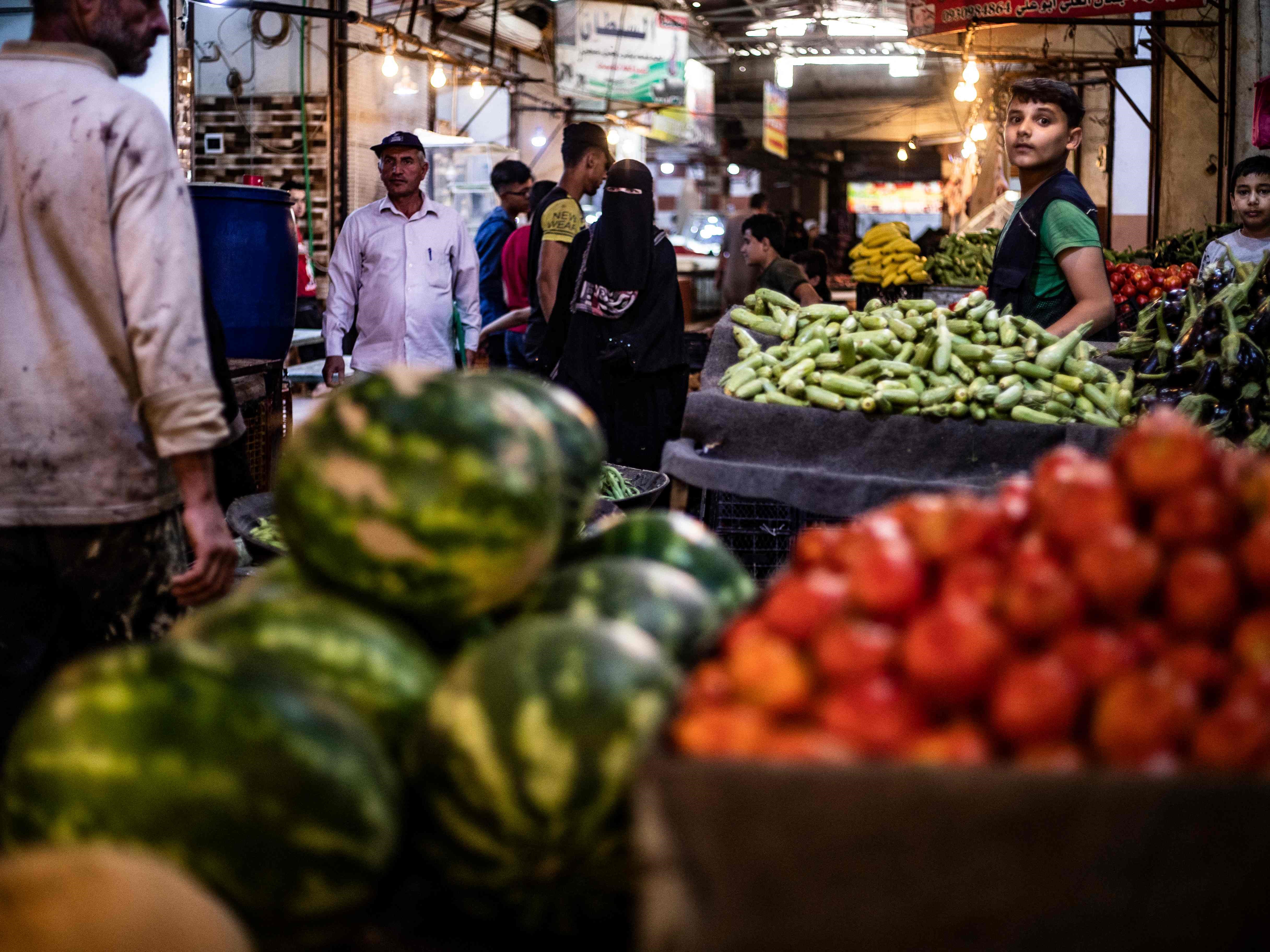 Orang-orang membeli produk segar dari kios-kios di kota Raqa, Suriah utara pada 19 Juni 2022. 
