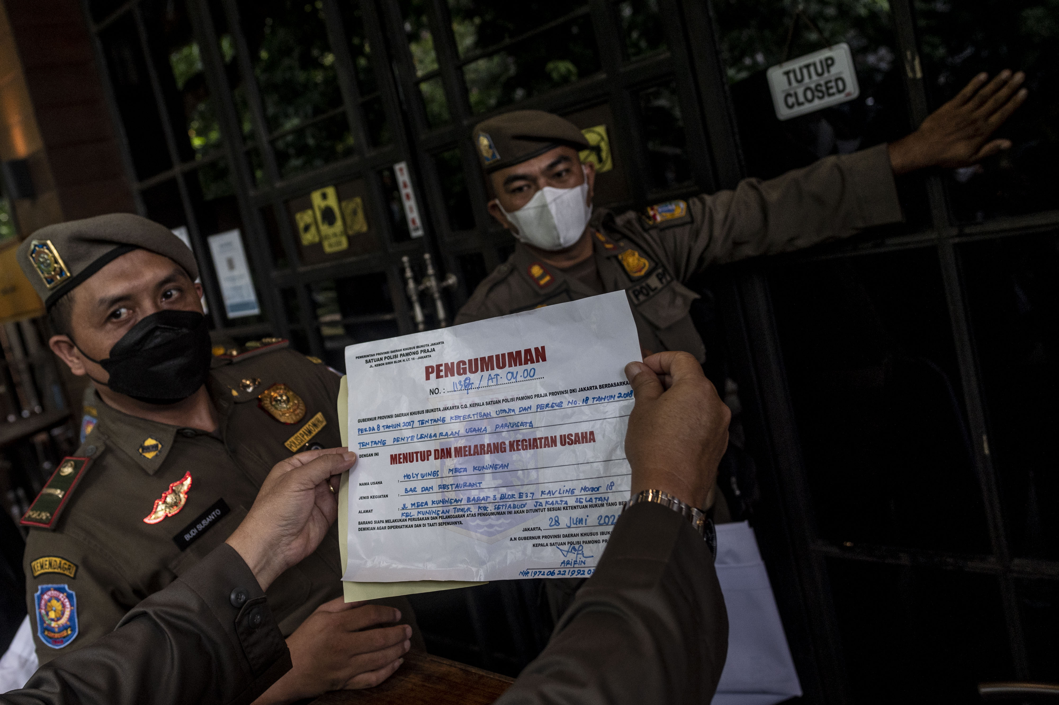 Satpol PP bersiap memasang stiker penyegelan outlet Holywings di kawasan Mega Kuningan, Jakarta, Selasa (28/6).