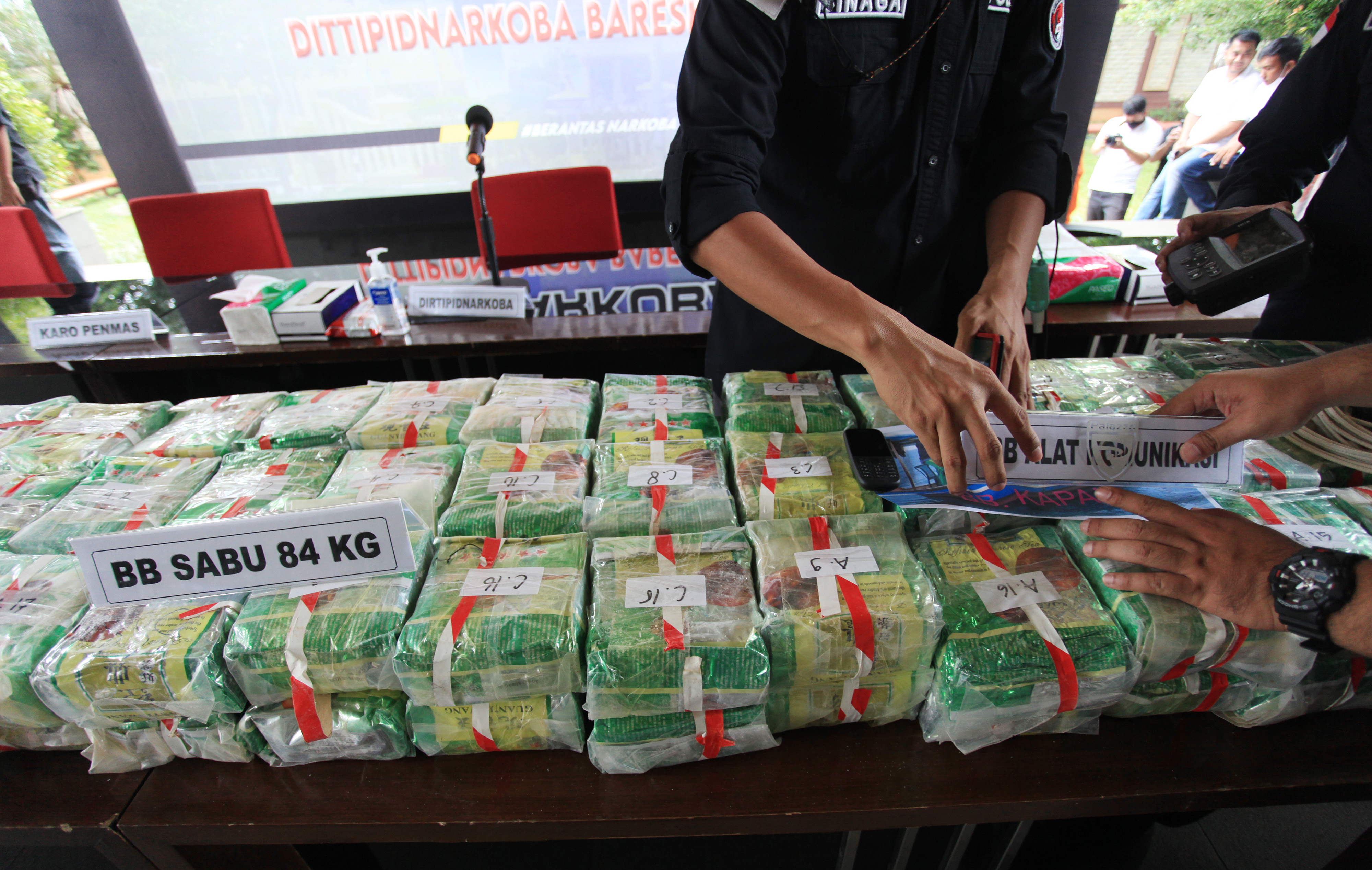 Ilustrasi polisi menunjukkan barang bukti narkoba