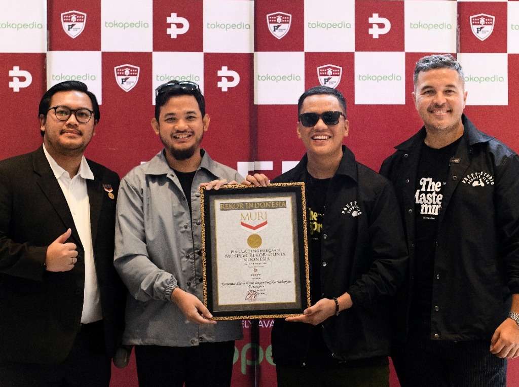Ketua Komunitas Skuter Matik Prepp Scooter Club, Rifat Sungkar (kanan) dan anggota berpose dengan menunjukkan piagam rekor MURI.