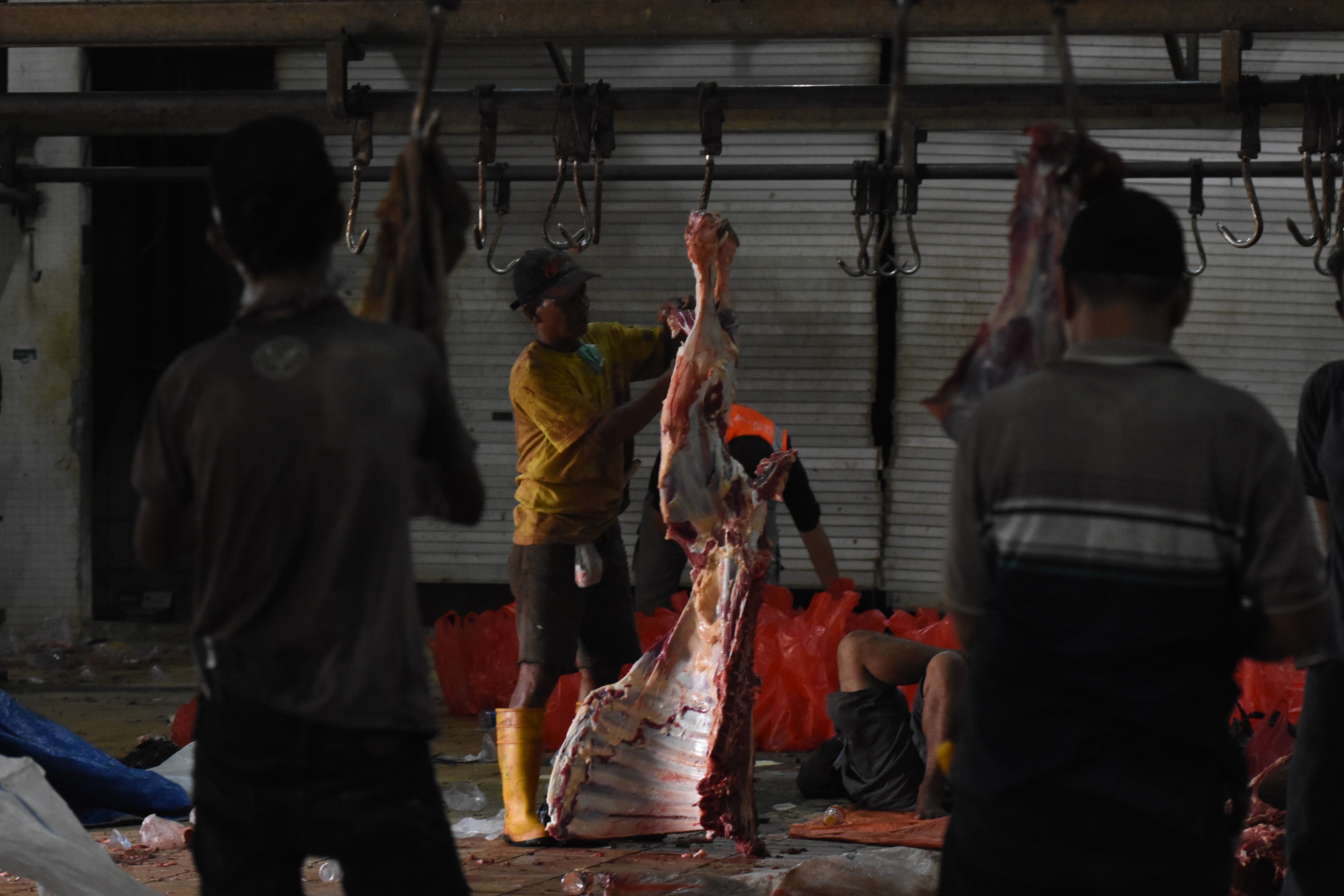 Petuigas memotong daging hewan kurban saat Idul Adha