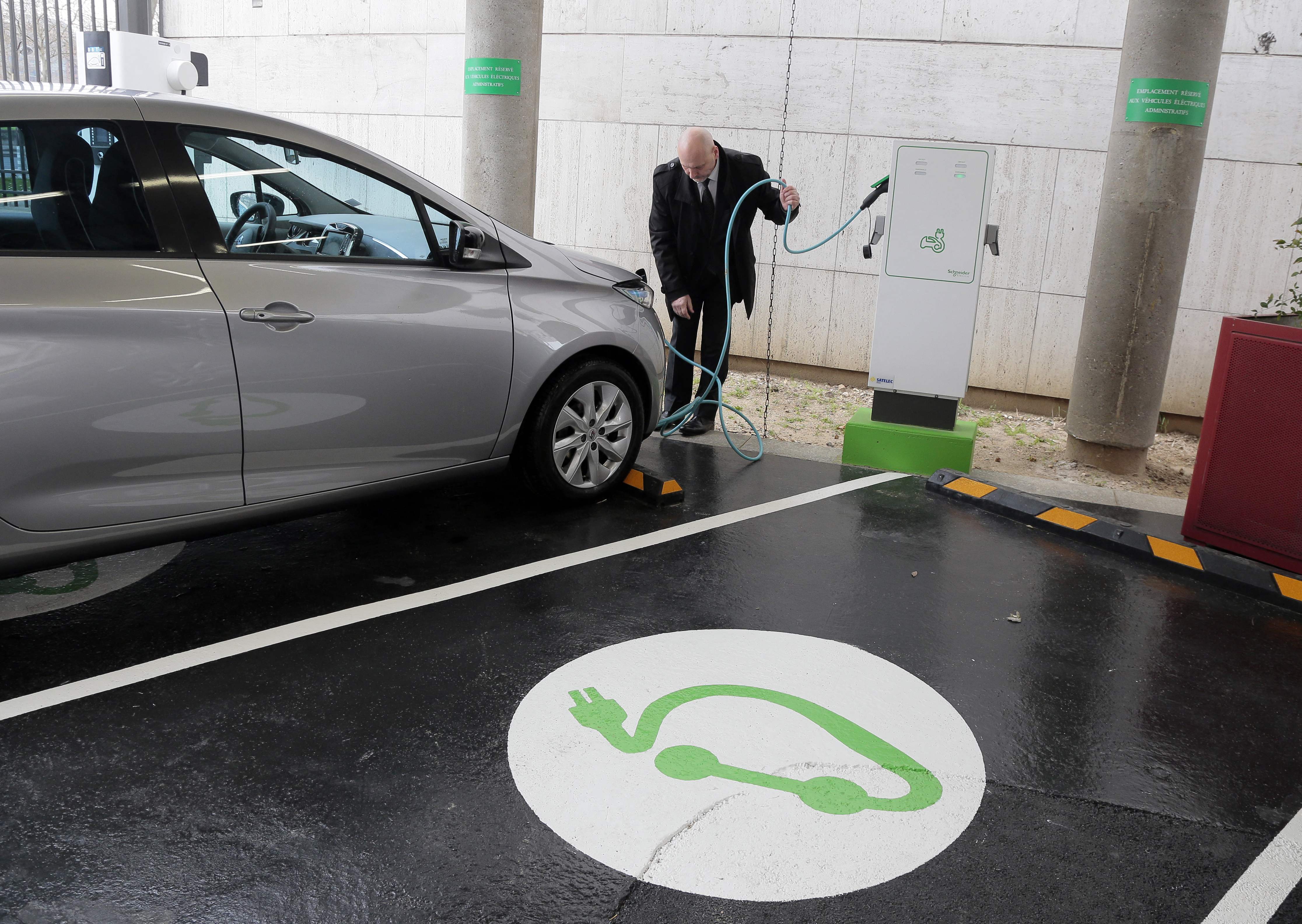 Seorang pengguna mobil listrik melakukan pengisian daya.