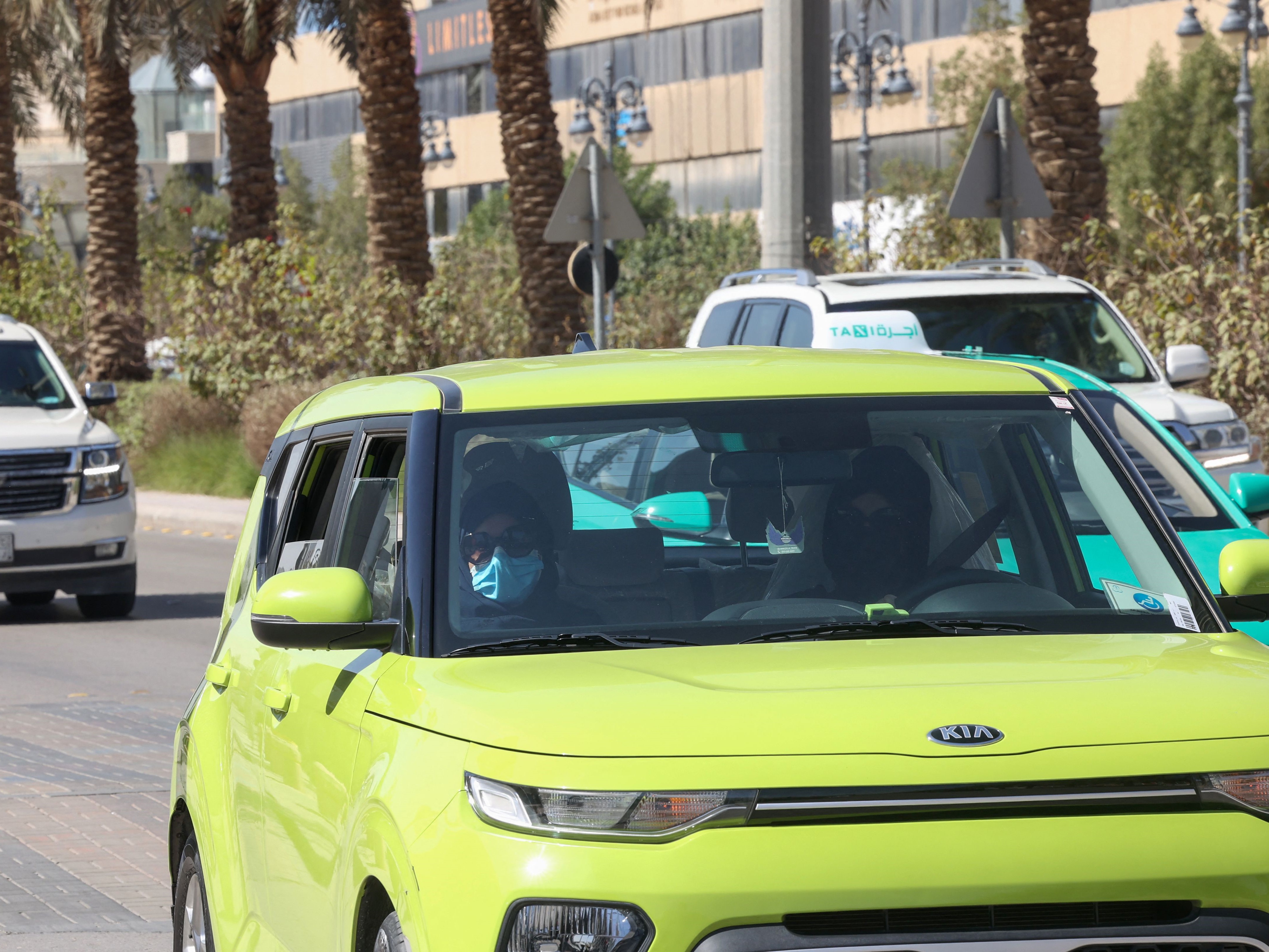 Sopir taksi Saudi Fahda Fahd (kanan) menyetir penumpang di jalan ibu kota Riyadh, pada 8 Februari 2022.