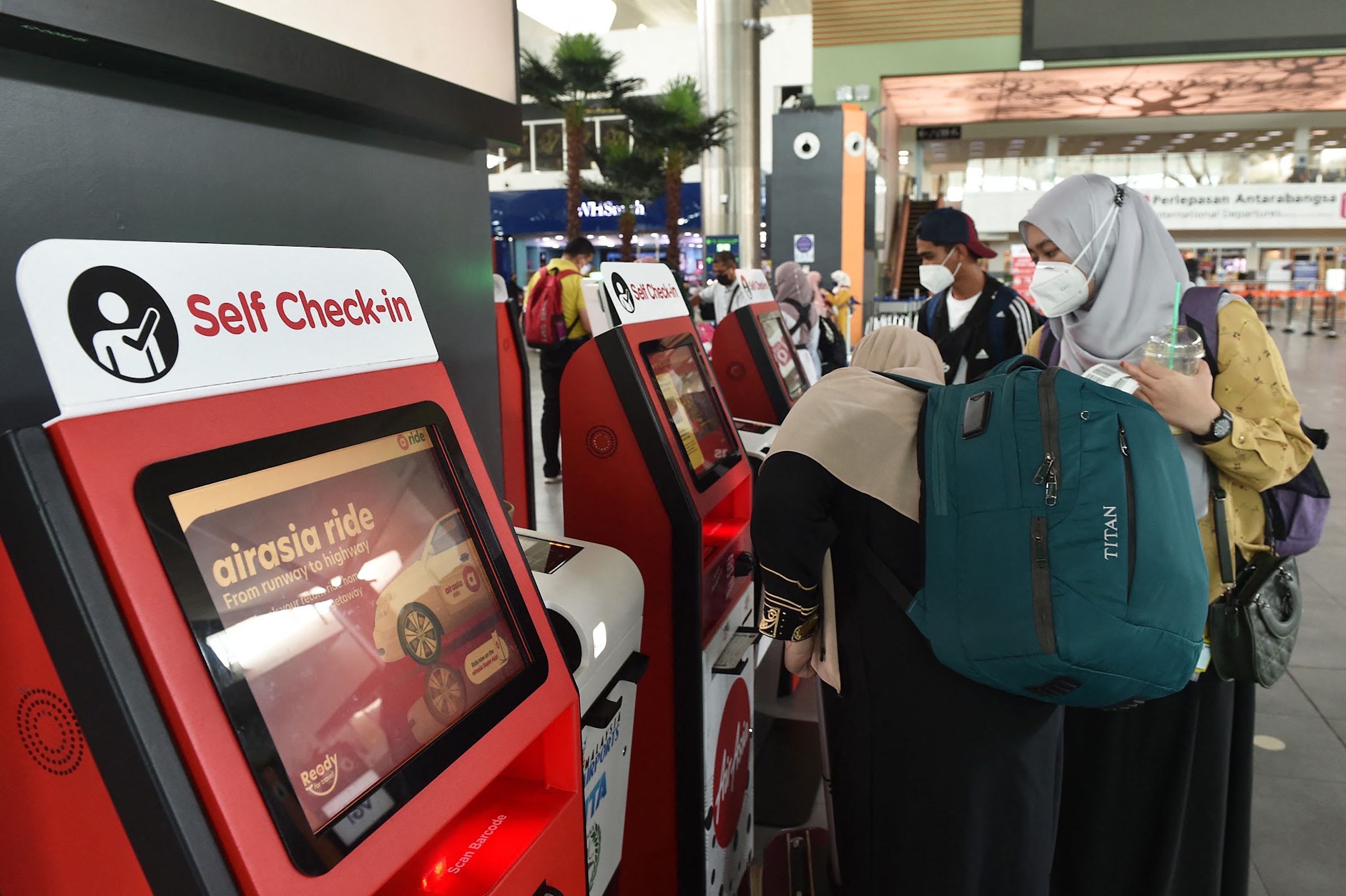 Calon penumpang melakukan check-in mandiri di Bandara Internasional Kuala Lumpur, Malaysia.