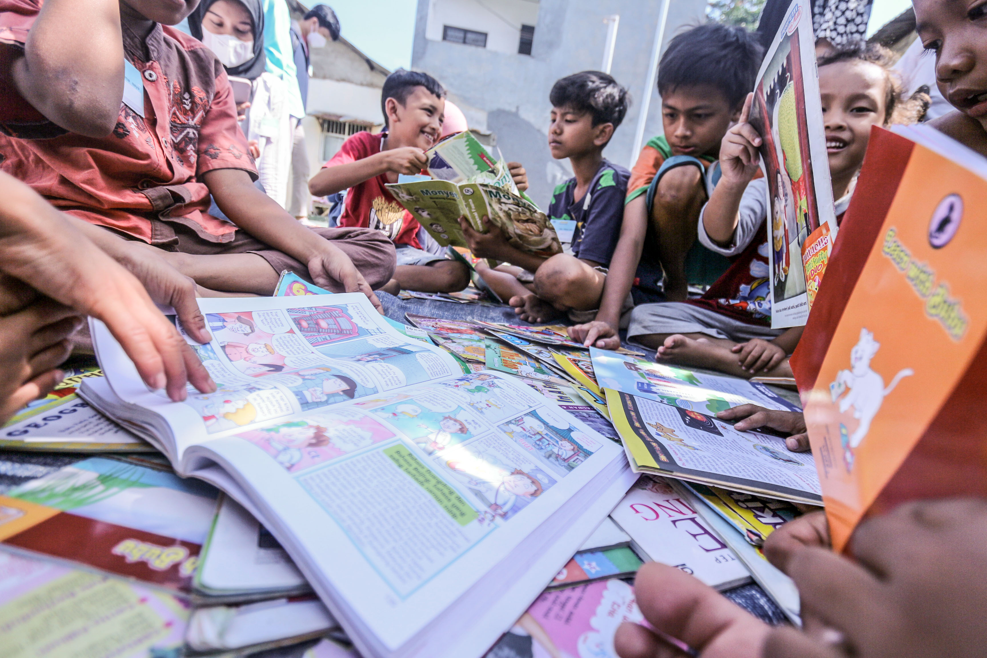 Sejumlah anak membaca buku yang dipinjam dari perpustakaan keliling di Pabuaran, Cibinong, Kabupaten Bogor, Jawa Barat.