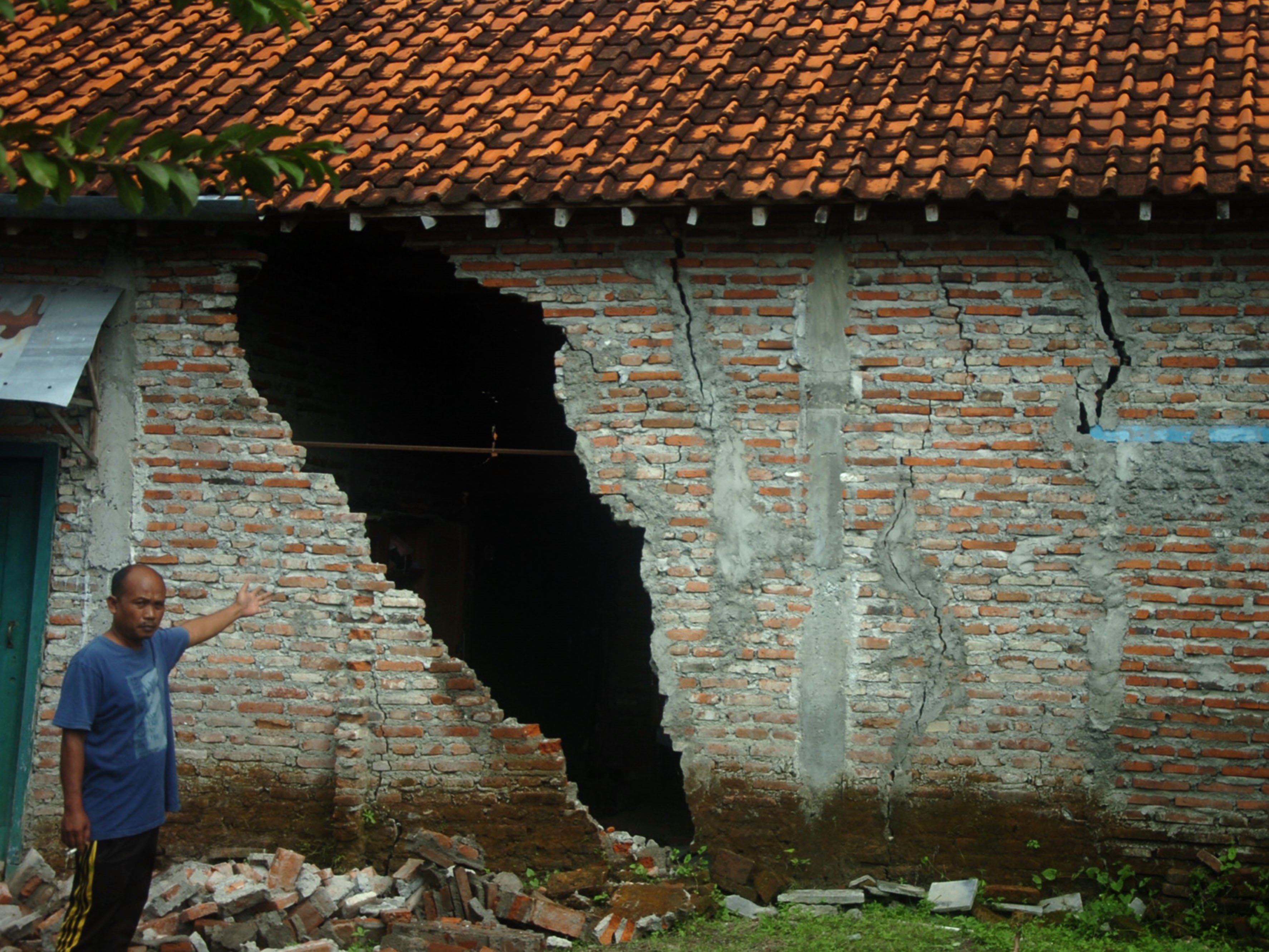 Warga menunjukkan tembok yang retak dan hancur akibat bencana tanah bergerak di Desa Kajen, Lebaksiu, Kabupaten Tegal, Jawa Tengah.