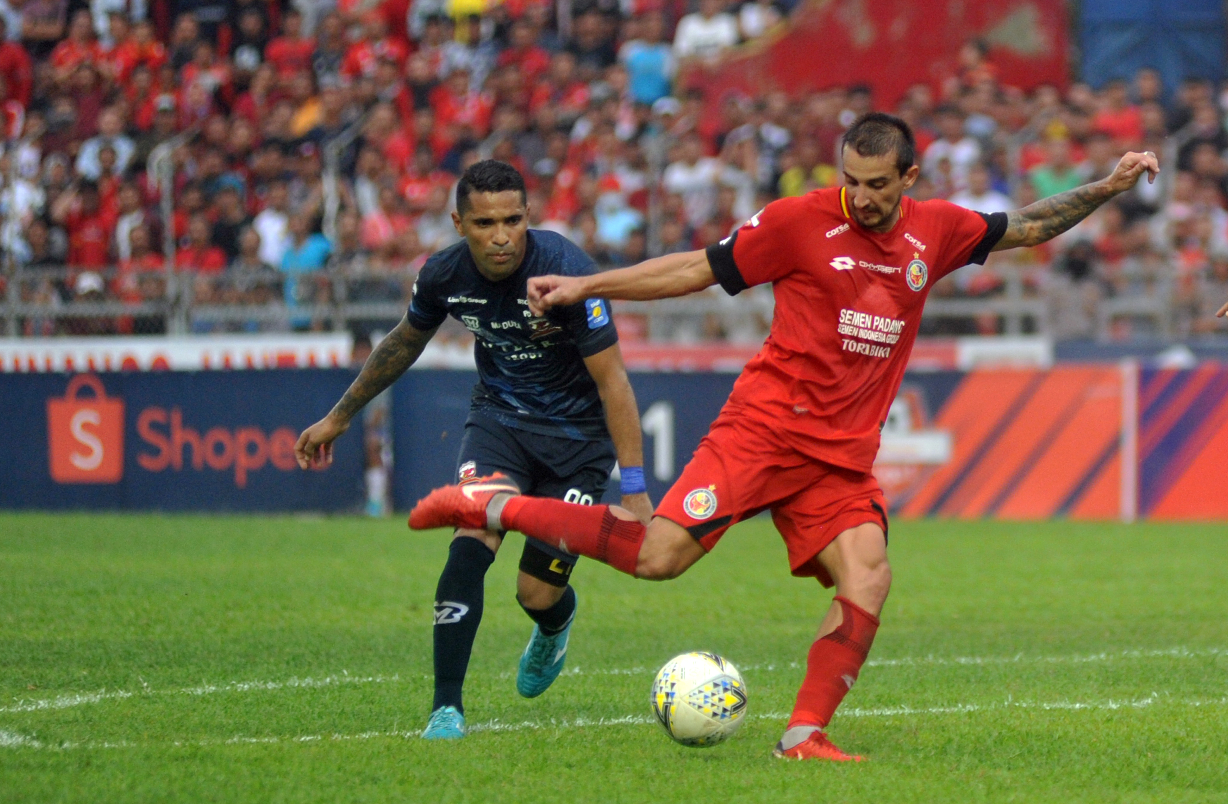 Pesepakbola Semen Padang FC, Flavio Beck Junior (kanan) melepaskan tendangan