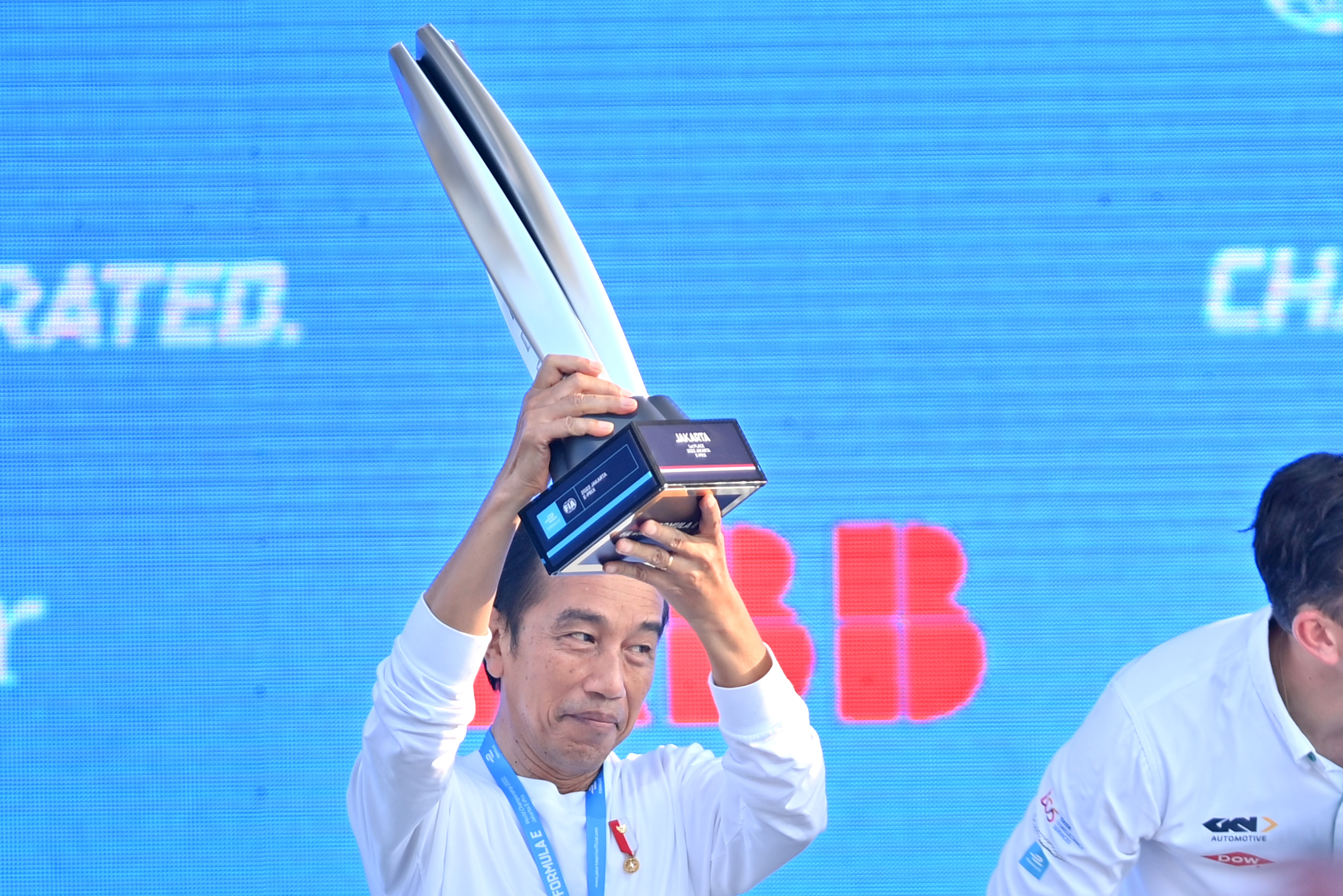  Presiden Joko Widodo bersiap menyerahkan piala ke pembalap Jaguar TCS Mitch Evans di podium.