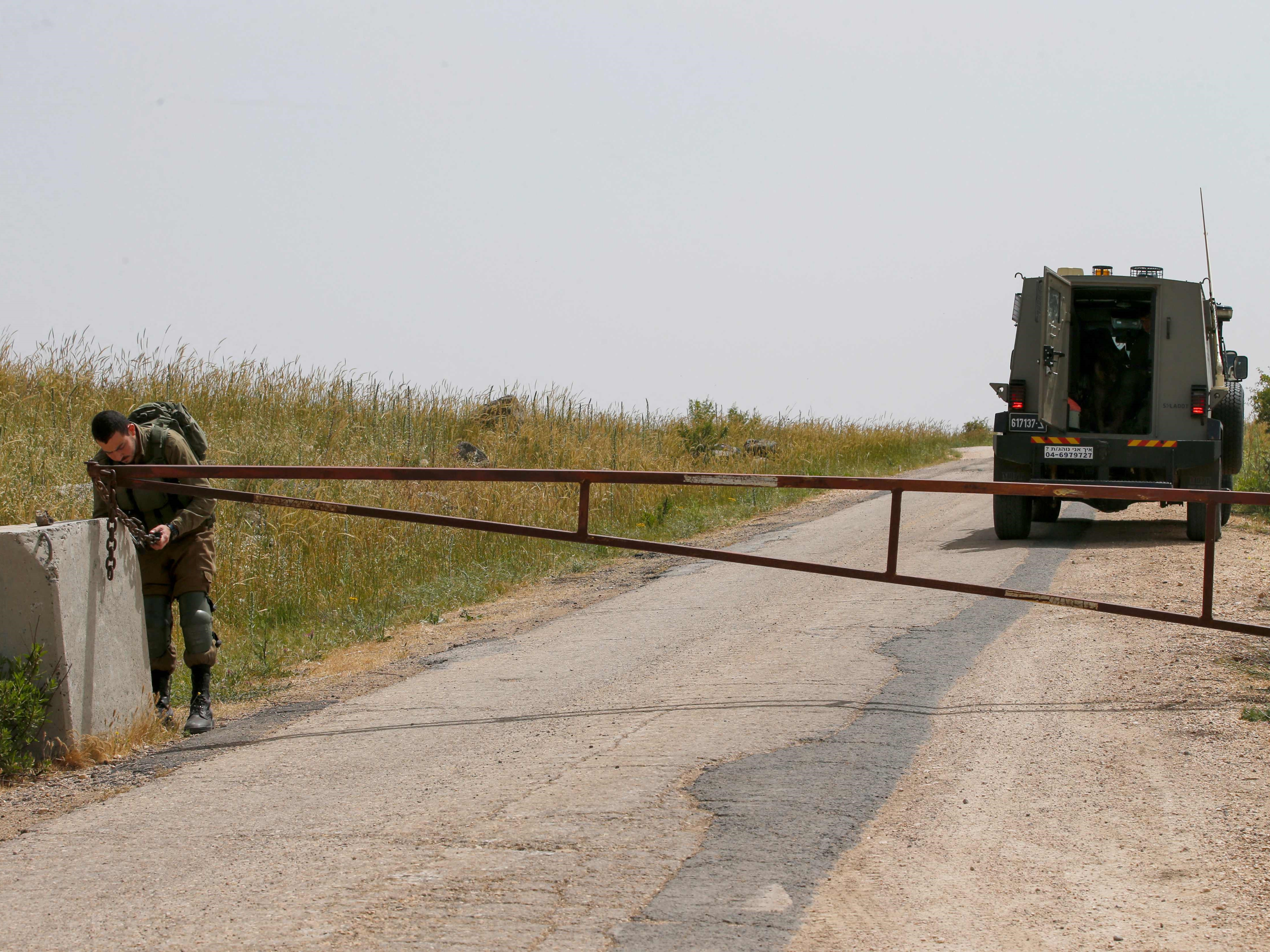 Seorang tentara Israel memblokade jalan perbatasan dengan Suriah, menyusul serangan udara Israel di Suriah tengah. 