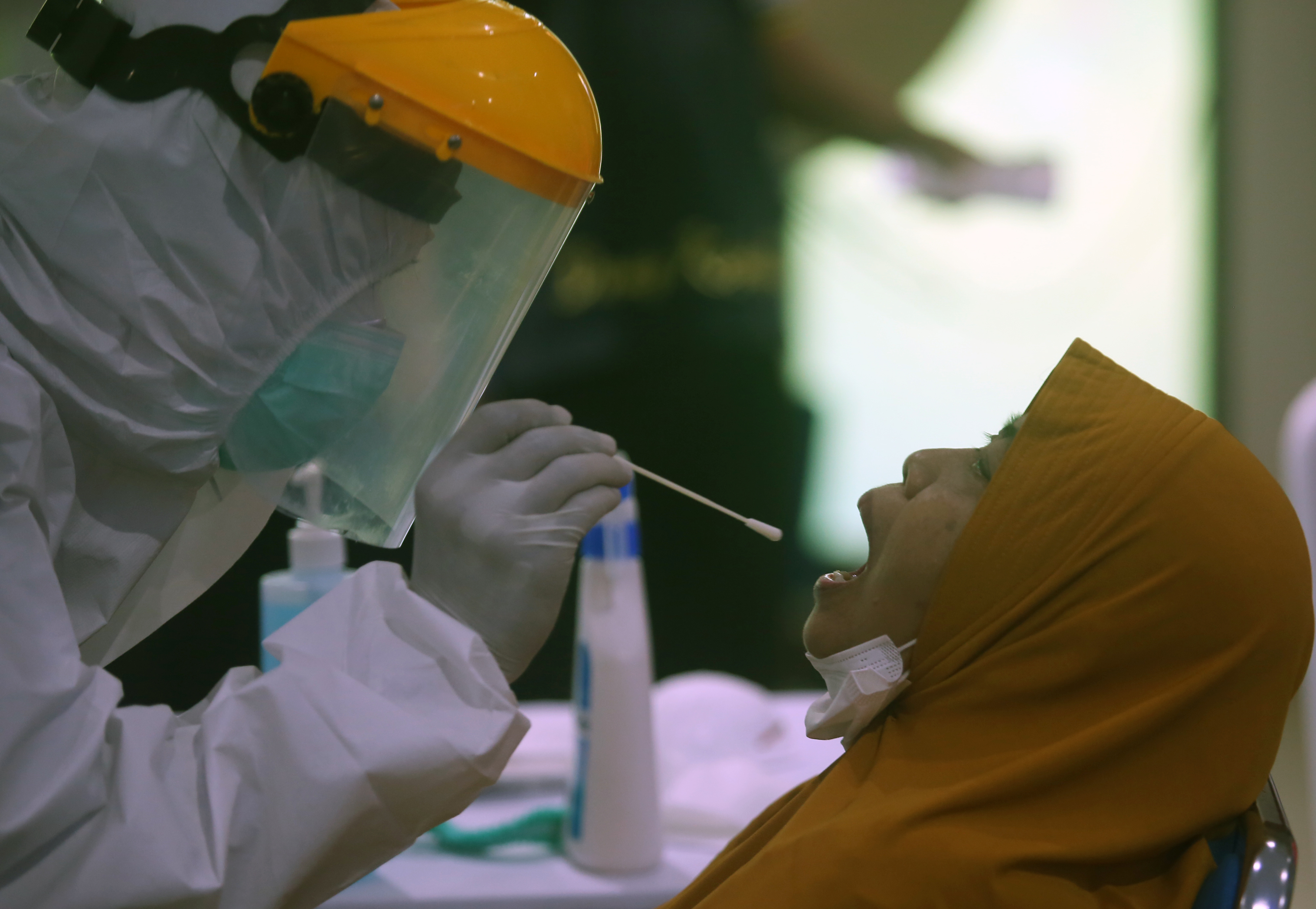 Petugas kesehatan melakukan tes usap PCR.