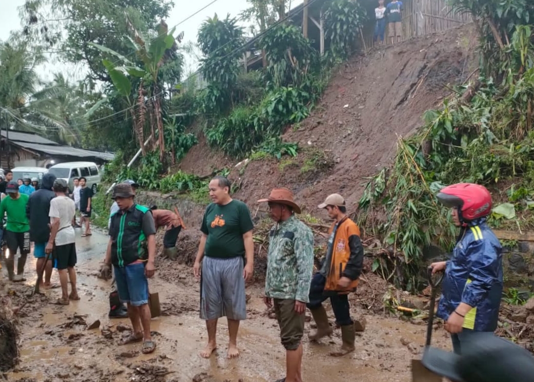 Sejumlah warga membersihkan material longsor yang menutup akses jalan di Kampung Cikubang RT 01 RW 19 Desa Mandalasari, 