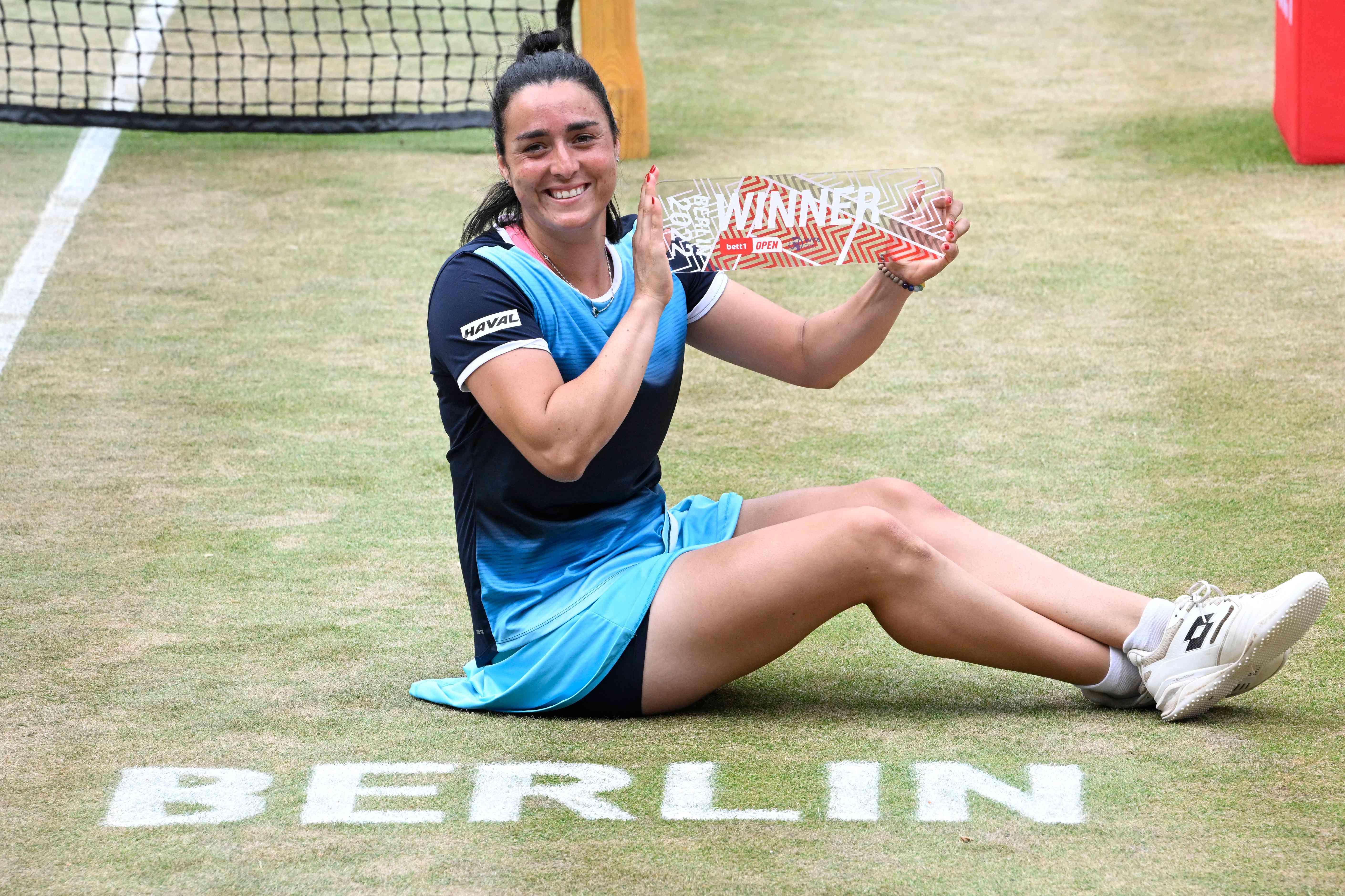Petenis Tunisia Ons Jabeur memamerkan trofi yang dimenangkannya di turnamen WTA di Berlin usai mengalahkan Belinda Bencic.