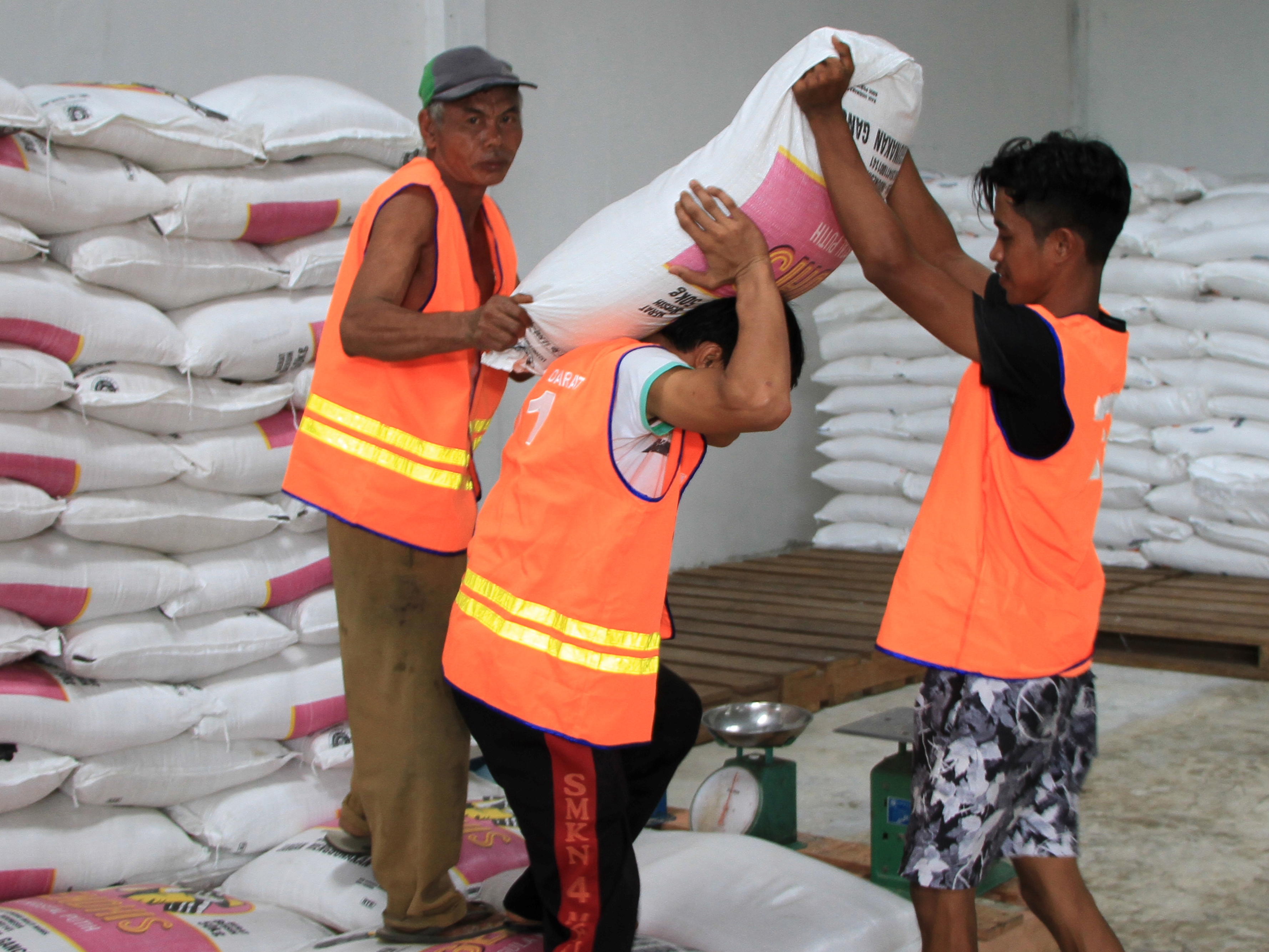 Pekerja memanggul karung berisi gula pasir di gudang Perum Bulog Cabang Meulaboh, Aceh Barat, Aceh, beberapa waktu lalu.