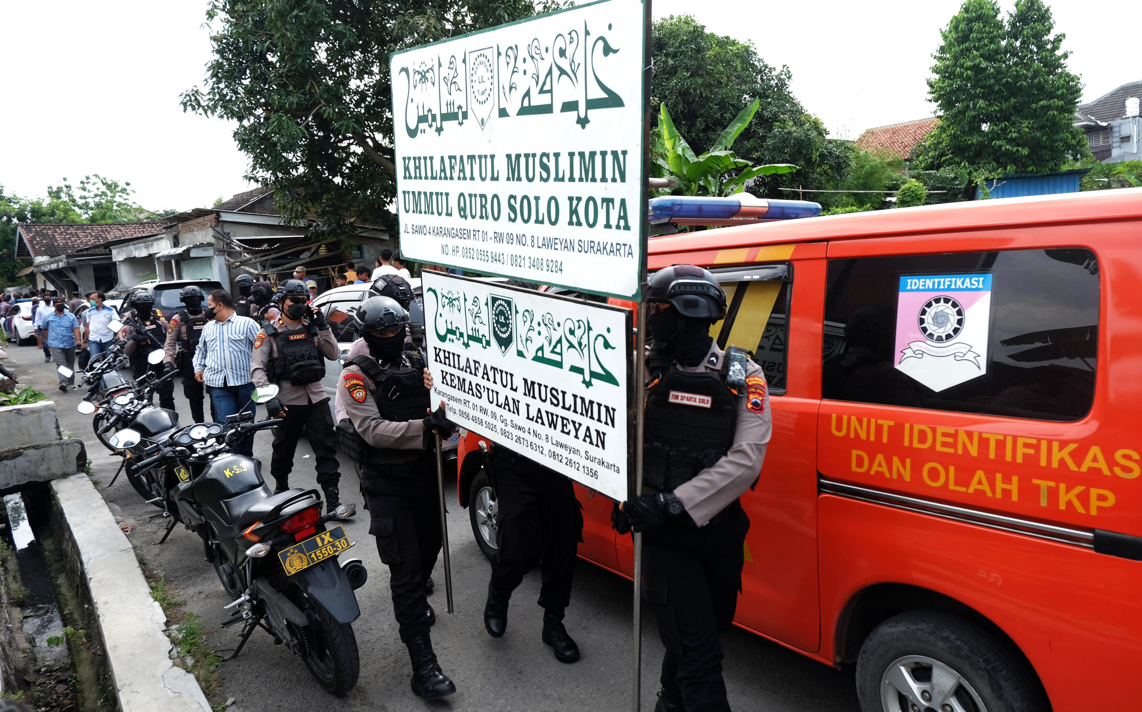 Polisi menurunkan papan bertulis Khilafatul Muslimin dari rumah warga sekaligus kantor cabang kelompok tersebut di Solo, Jawa Tengah.