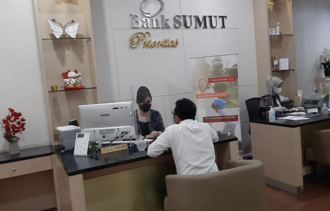Seorang karyawan Bank Sumut tengah melayani nasabah