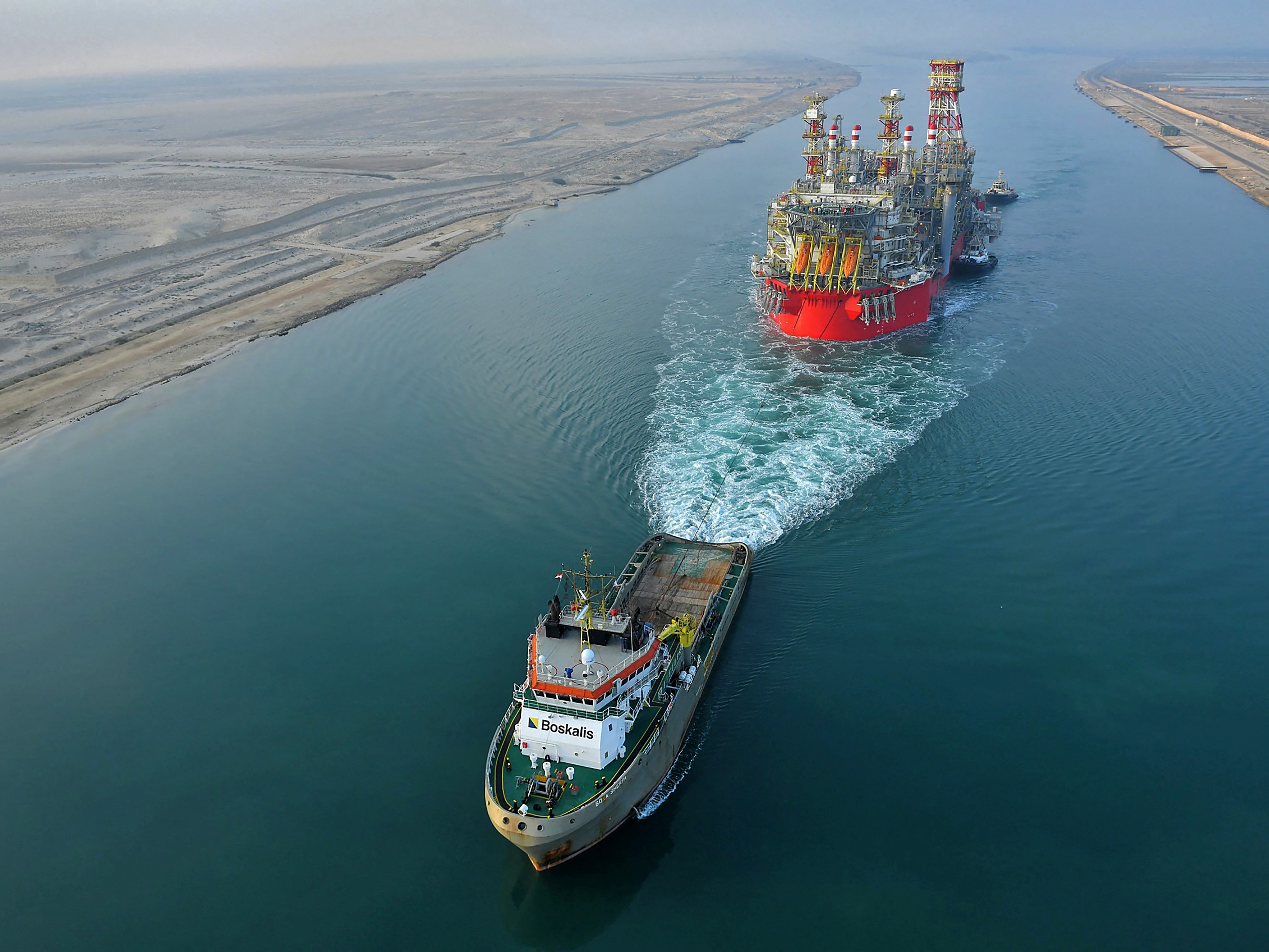 Kapal tunda yang menarik kapal Energean Floating Production Storage and Offloading (FPSO) di sepanjang Terusan Suez Mesir.