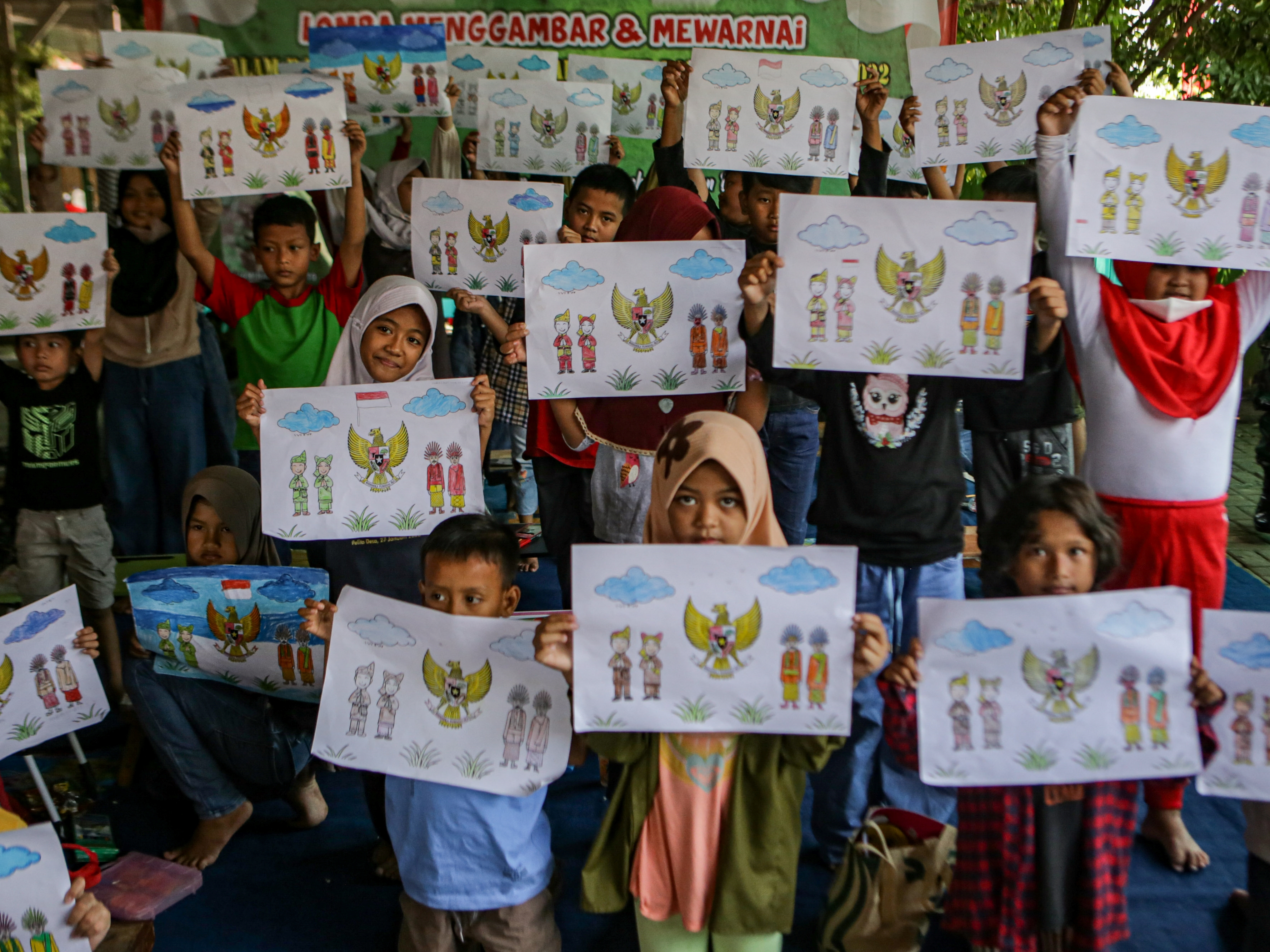 Sejumlah anak usia sekolah menunjukkan hasil mewarnai lambang negara Garuda Pancasila di Kampung Teras Pancasila, Karang Tengah, Tangerang.