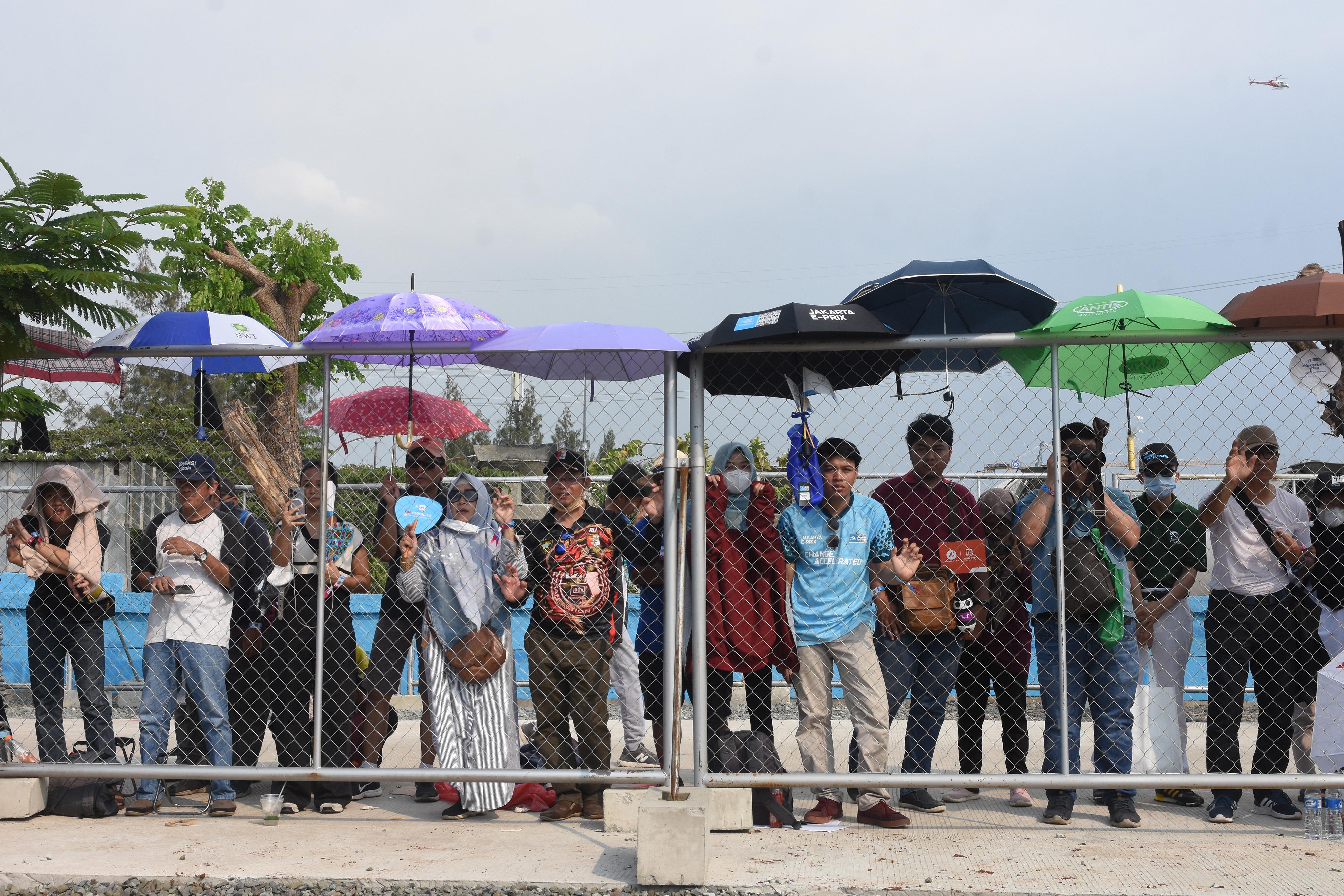 Penonton menyaksikan ajang balap Formula E seri kesembilan dari luar pagar pembatas lintasan di Jakarta International E-Prix Circuit (JIEC).
