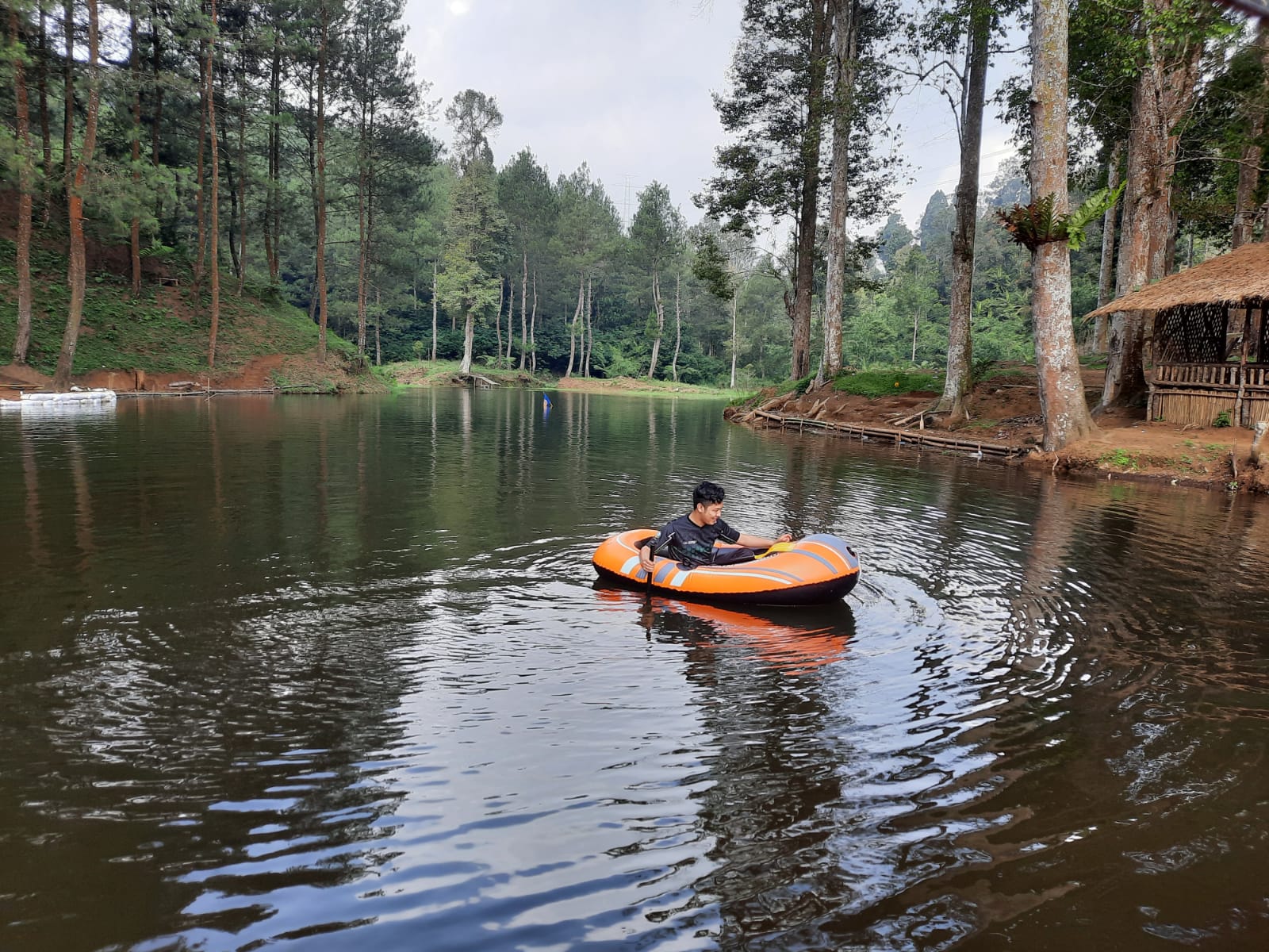 Seorang wisatawan menikmati wahana perahu di kawasan wisata alam Cigunung Tugu, Desa Pasawahan, Kabupaten Cianjur, Jawa Barat.