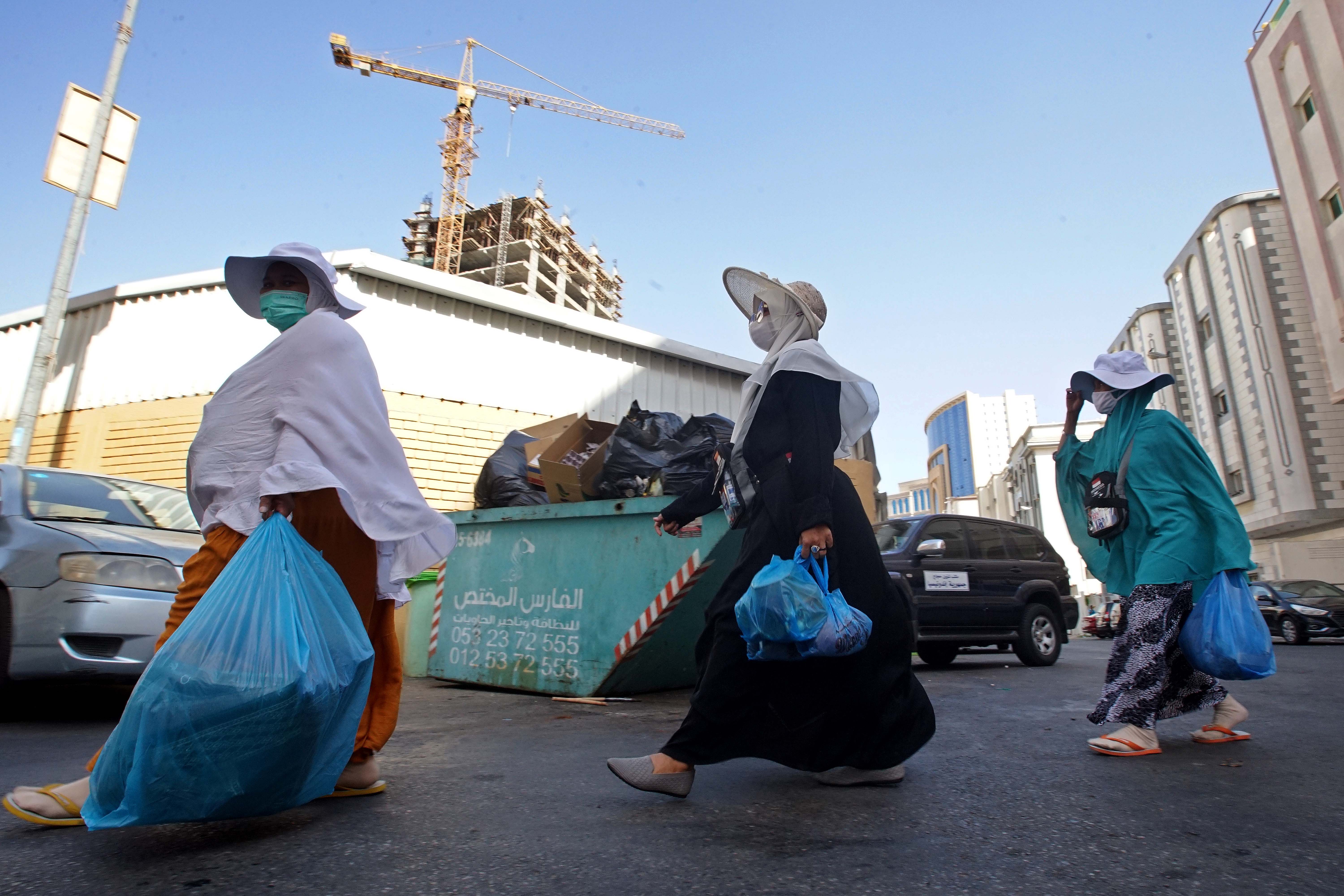 Jemaah haji Indonesia kembali ke hotel usai berbelanja di toko peralatan ibadah dan suvenir di kawasan Mekah, Arab Saudi, Jumat (1/7).