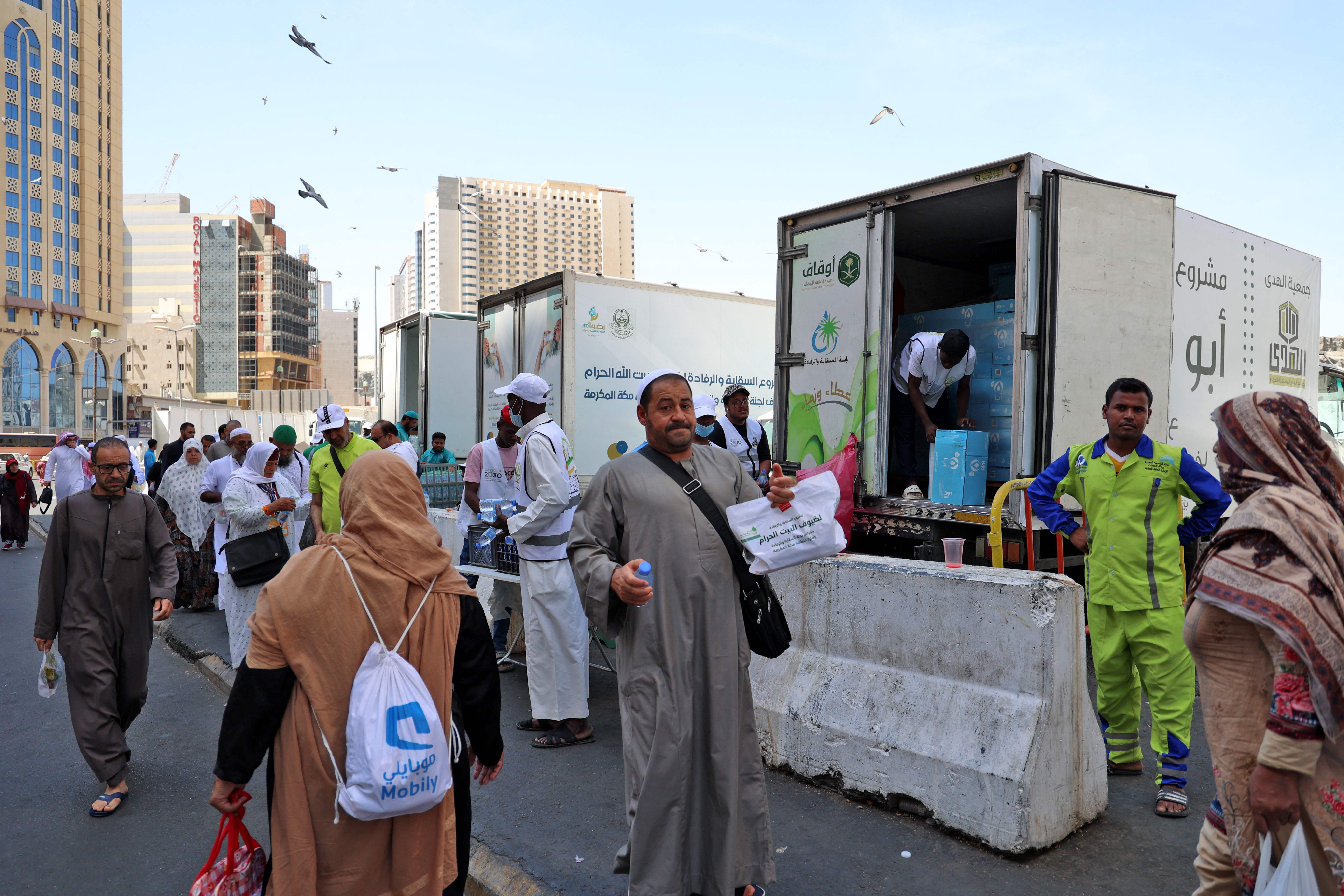 Jemaah menerima botol air di luar Masjidil Haram di Mekkah, Arab Saudi, Selasa (5/7/2022)