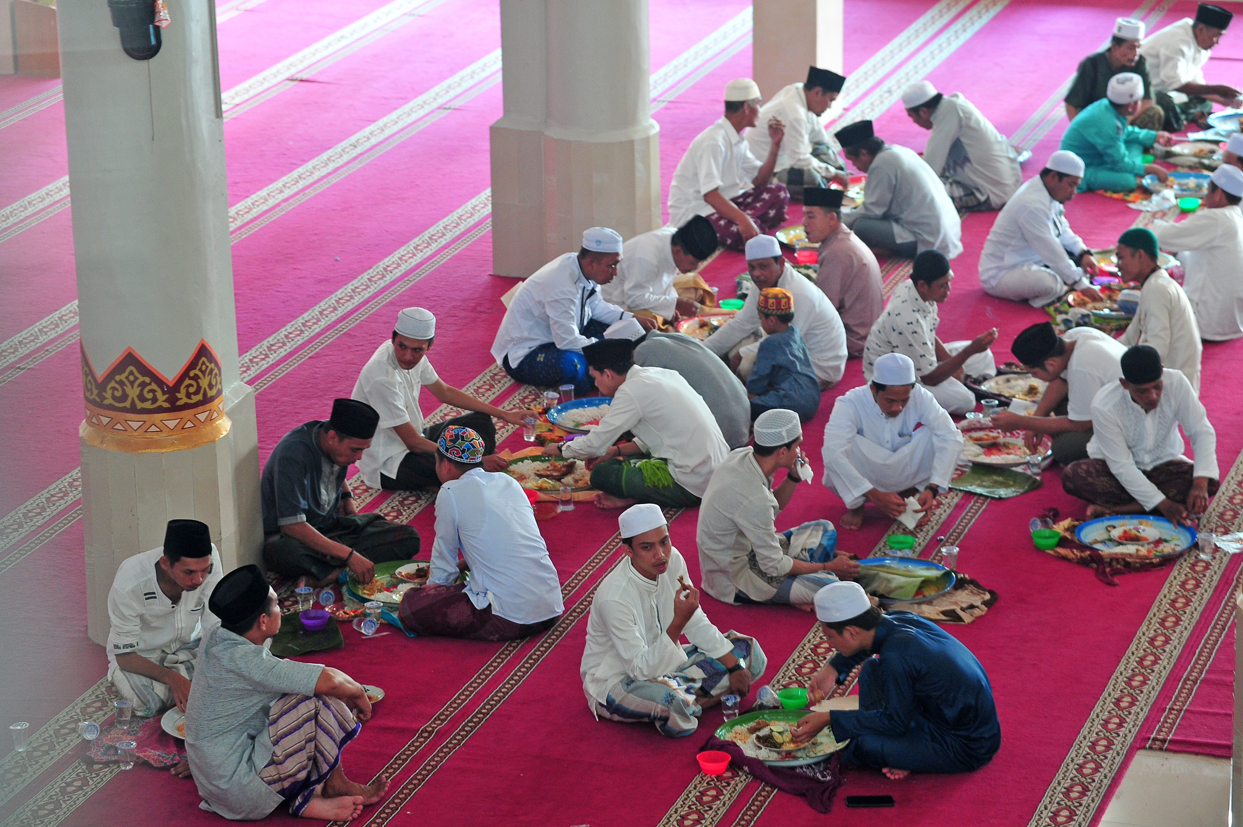 Warga menyantap hidangan yang disajikan di atas nampan bulat khas Melayu Jambi saat perayaan Idul Adha 1442 di Masjid Al-Ihsaniyah, Jambi.