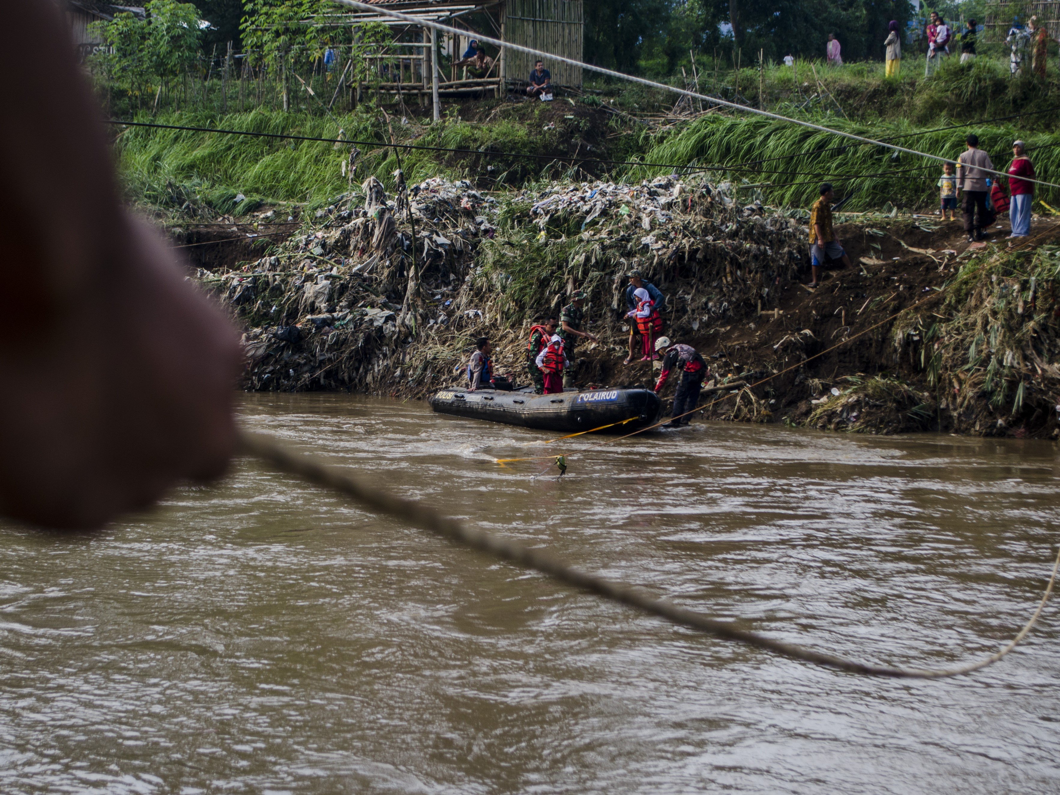 Tim SAR gabungan membantu pelajar menaiki perahu karet untuk menyebrangi Sungai Cimanuk, Garut, Jawa Barat, Selasa (19/7/2022).