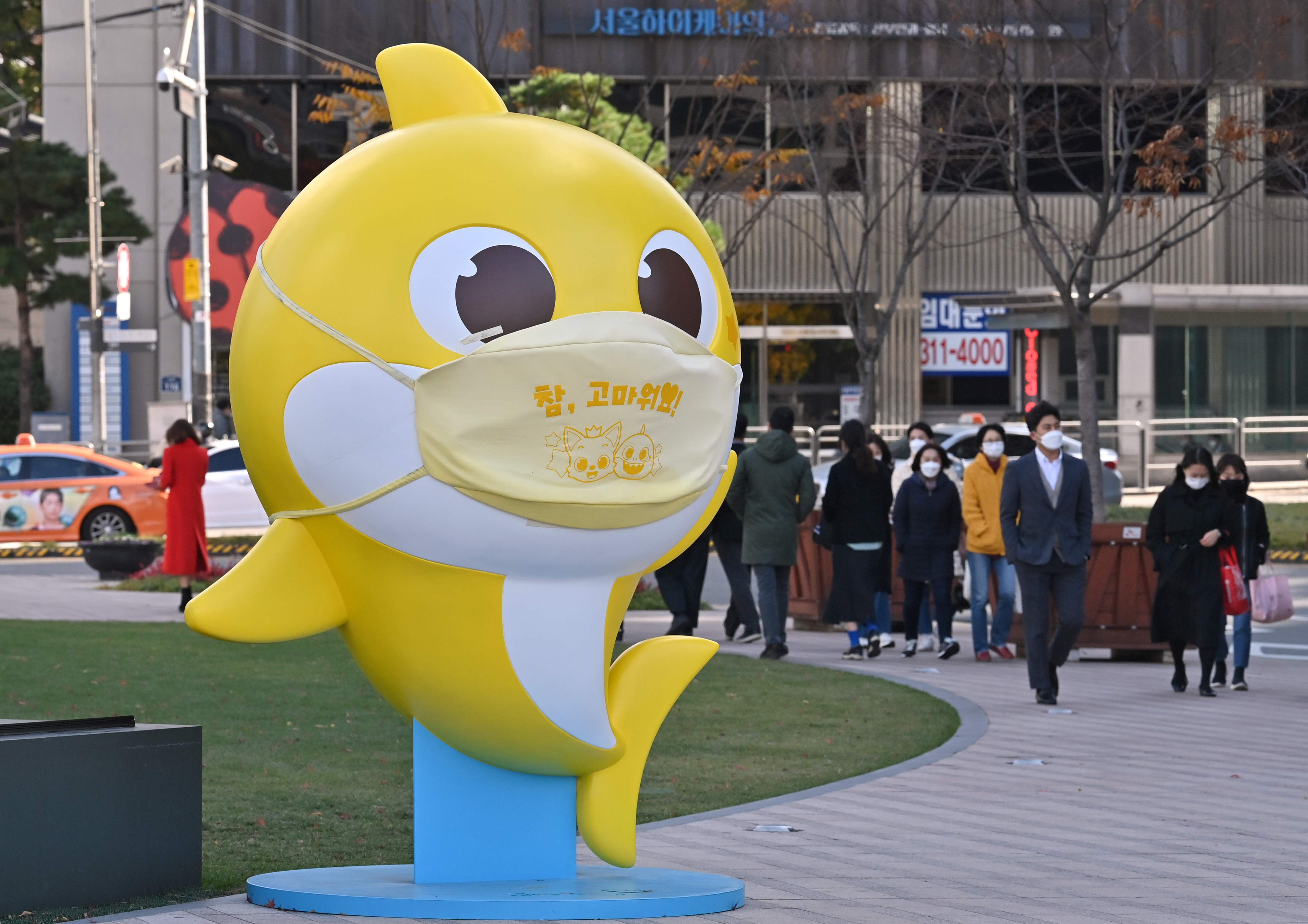 Warga melintas di depan patung karakter Baby Shark di Seoul, Korea Selatan