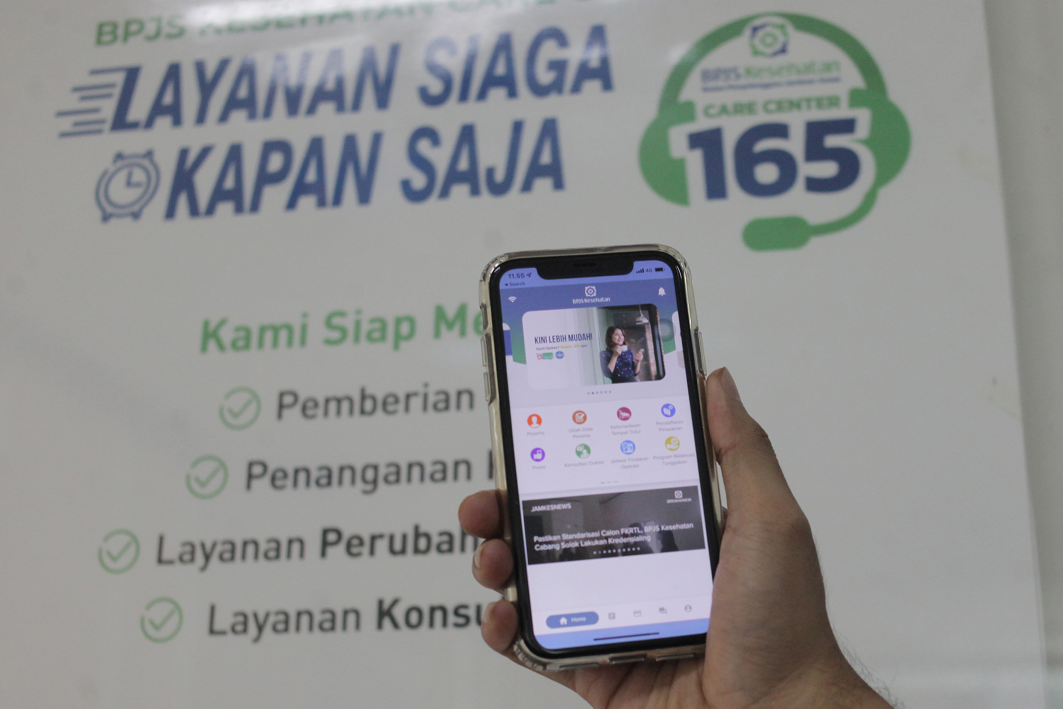 Warga menunjukkan fitur terbaru layanan BPJS Kesehatan.