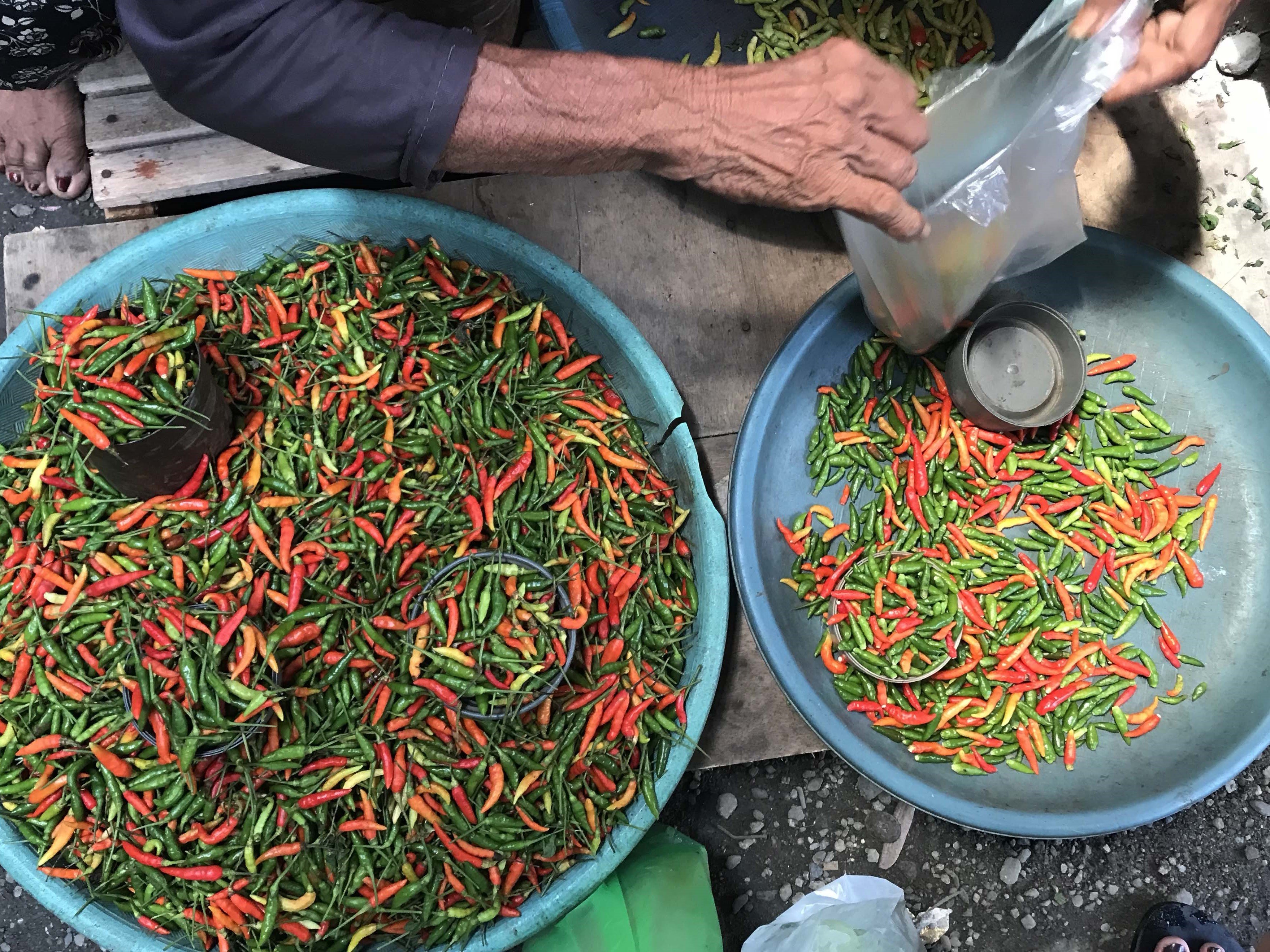 Pedagang melayani pembeli cabai rawit di Pasar Tradisional Inpres Manonda di Palu, Sulawesi Tengah, Jumat (1/7).