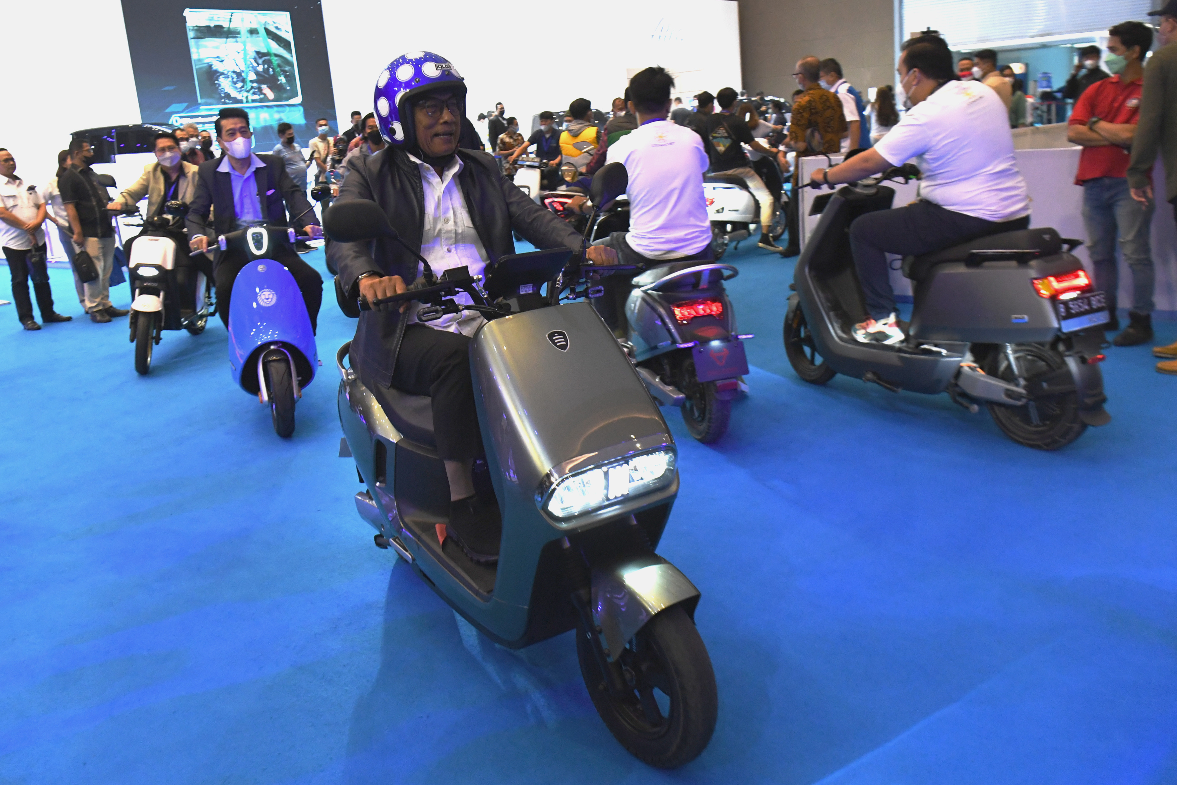 Kepala Staf Kepresidenan Moeldoko saat mencoba motor listrik di sebuah pameran.