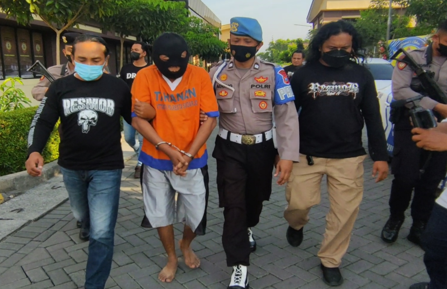Petugas menggiring J (kaos oranye), pembunuh bos barang bekas di Sidoarjo, Jawa Timur.